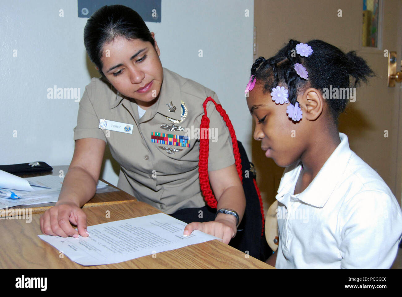 NORTH CHICAGO, Ill. (Feb. 8, 2010) -- Ship's Serviceman 1st Class(SW/AW) Laura Perez, a Recruit Division Commander (RDC) from the Navy's ony boot camp, Recruit Training Command (RTC) at Naval Station Great Lakes, Ill., assists third-grader Ciera Bell with her reading skills at Hart Elementary School in North Chicago, Ill., Feb. 9. Perez has been instrumental in helping to coordinate the Adopt-a-School reading program between RTC and the school. Volunteers visit the school each week to sit with students on a one-on-one basis to help improve their reading skills. Stock Photo