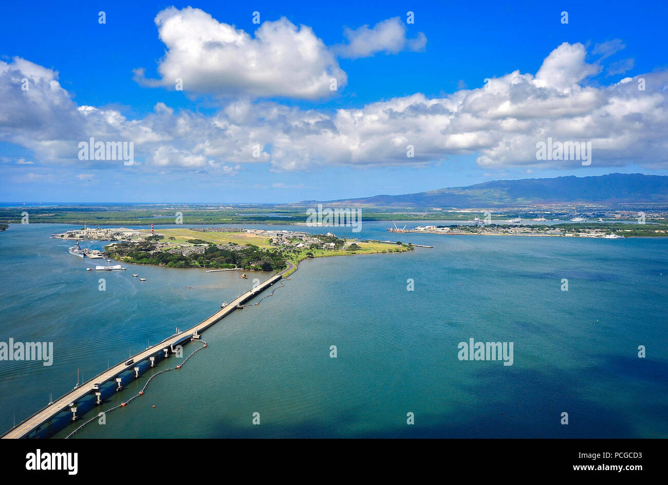 An aerial view of the Waianae Mountains, right background, along with the Battleship Missouri Memorial, the USS Arizona Memorial and Ford Island, can be seen at Joint Base Pearl Harbor-Hickam, Hawaii, March 30, 2014. Stock Photo