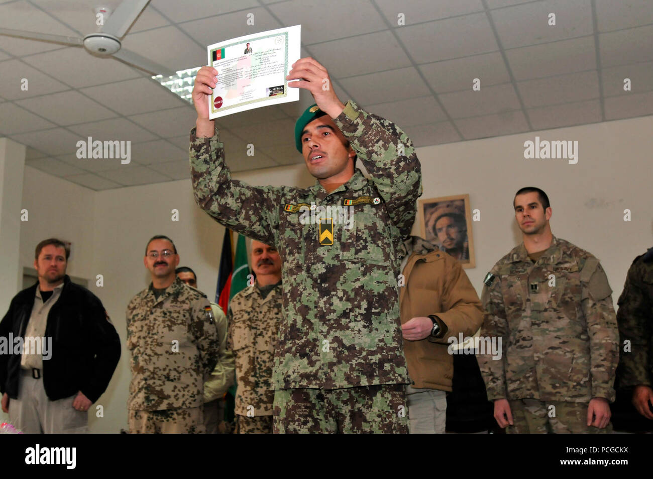 An Afghan National Army soldier proudly displays his certificate during a graduation ceremony held at the Afghan National Army Engineer School near Camp Spann, Dec. 15. Fifteen Afghan servicemen graduated in the ceremony and can now wear the Explosive Ordnance Disposal patch and badge after completing 22 weeks of intensive EOD and Improvised Explosive Device Defeat training. The Engineer School is the only one in Afghanistan that teaches the fundamentals of EOD and IEDD to Afghan National Security Forces. International Security Assistance Force Regional Command North supports Afghan National S Stock Photo