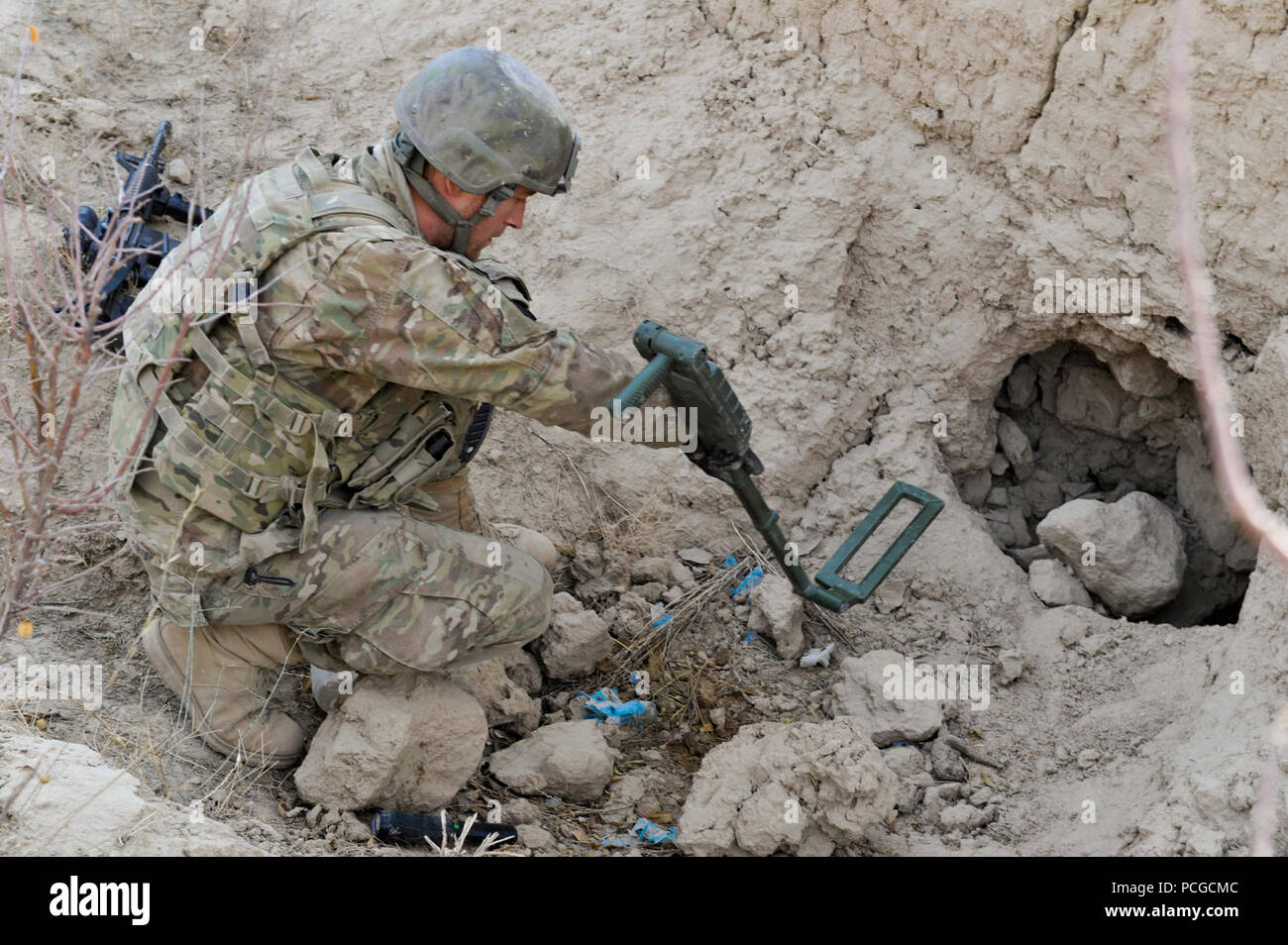 A member of coalition Special Operations Forces uses a metal detector to search for a suspected weapons cache during a patrol led by Afghan Local Police in Walan Rabat village, Zabul Province, Afghanistan, Jan. 4. Stock Photo