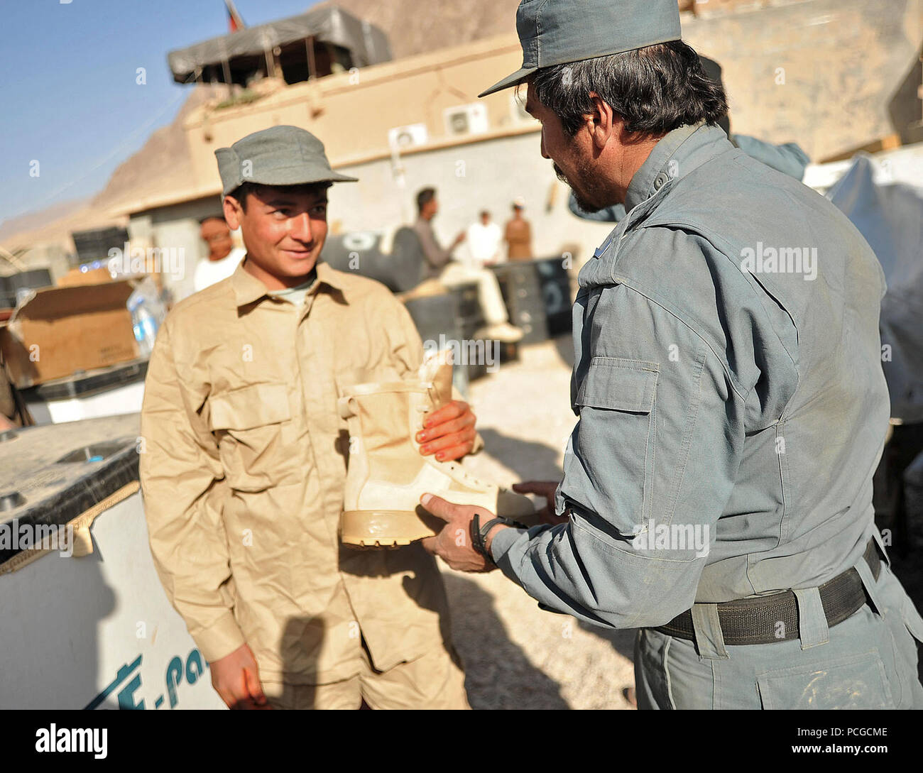 An Afghan Local Police recruit receives his boots from an instructor in Gizab district, Uruzgan province, Afghanistan, Dec 28. The ALP is a defensive, community-oriented force that brings security and stability to rural areas of Afghanistan. Stock Photo