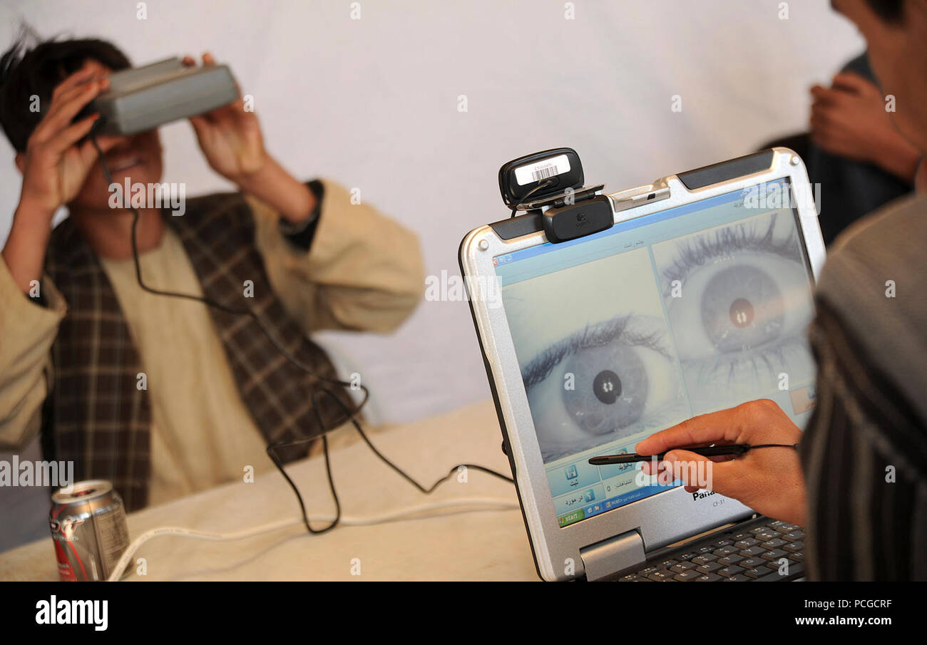 A member of the Afghan Local Police looks into a biometric eye scanner while being processed into the ALP by members of the Afghan Ministry of Interior in Gizab district, Uruzgan province, Afghanistan, Dec. 18. The ALP is a defensive, community-oriented force that brings security and stability to rural areas of Afghanistan. Stock Photo