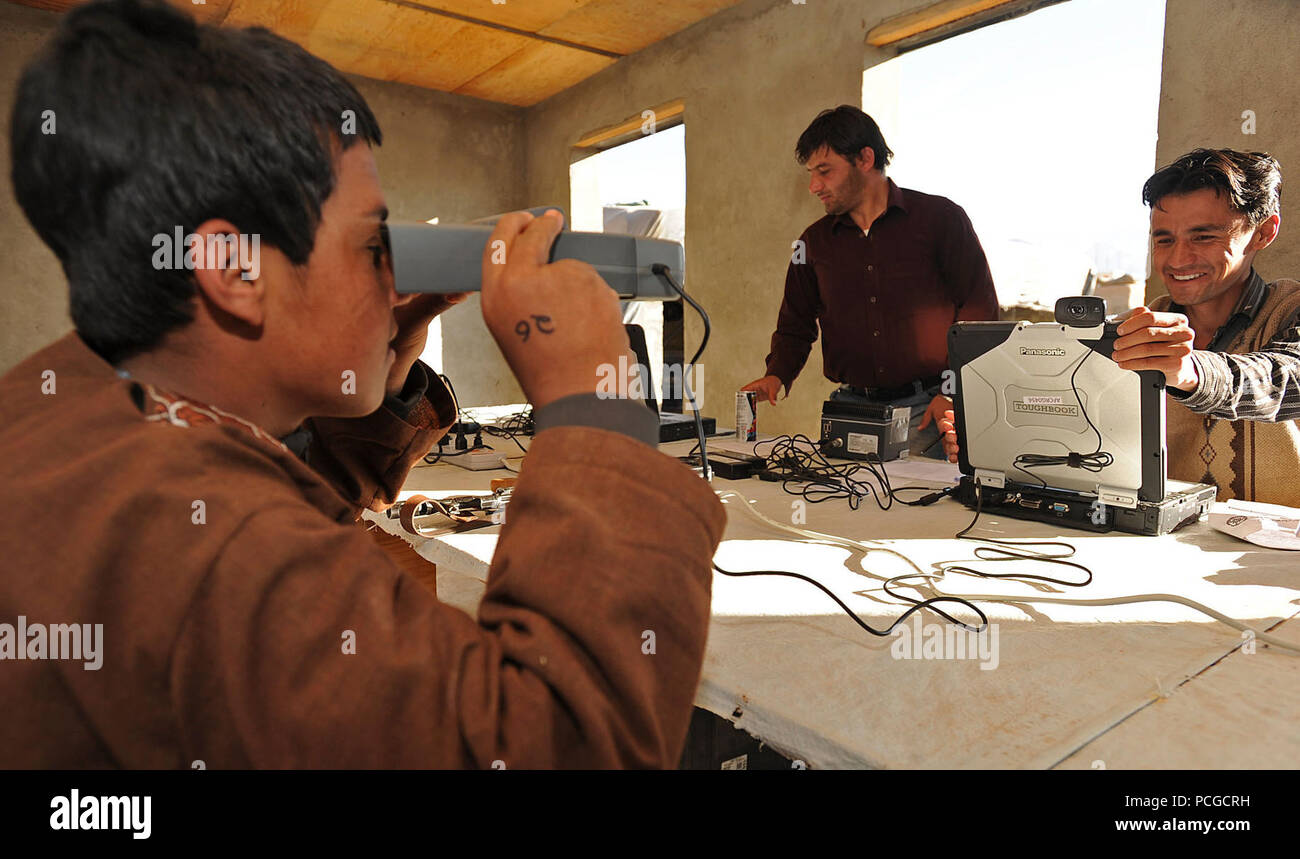 A member of the Afghan Local Police looks into a biometric eye scanner while being processed into the ALP by members of the Afghan Ministry of Interior in Gizab district, Uruzgan province, Afghanistan, Dec. 18. The ALP is a defensive, community-oriented force that brings security and stability to rural areas of Afghanistan. Stock Photo