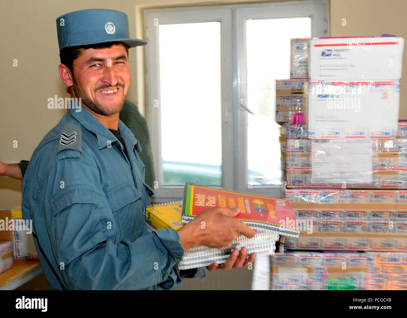 KABUL, Afghanistan – A Afghan National Civil Order Police Sergeant helps load boxes of school supplies to be distributed to a local school. ANCOP Command Sgt. Maj. Abdul Wihad spearheads the donation of school supplies which takes place once a month Stock Photo