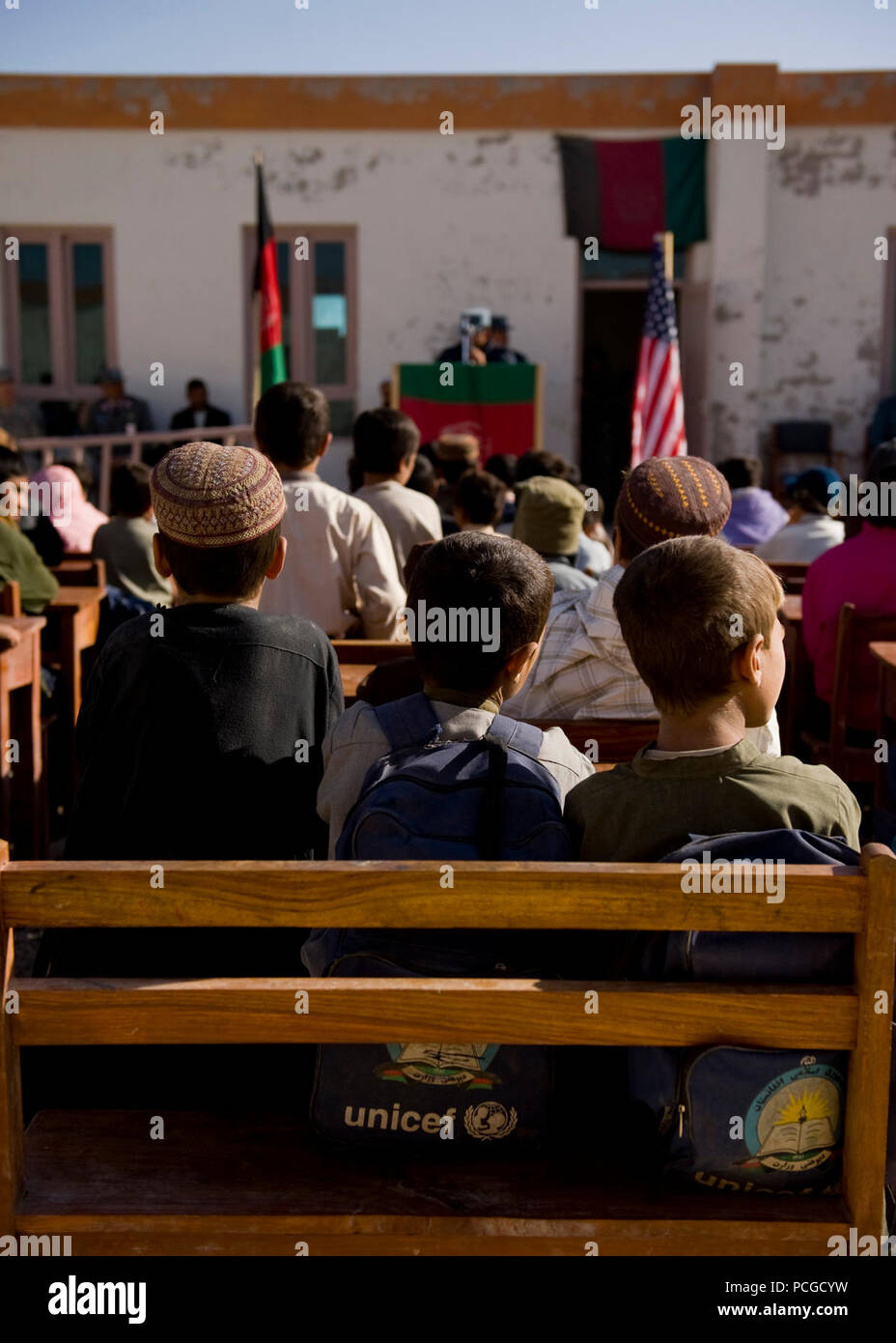 At an elementary school near Kandahar Air Field, children sit during a visit from local police and coalition leaders. Both spoke to the children on the importance of education and good behavior before handing out school supplies. Stock Photo