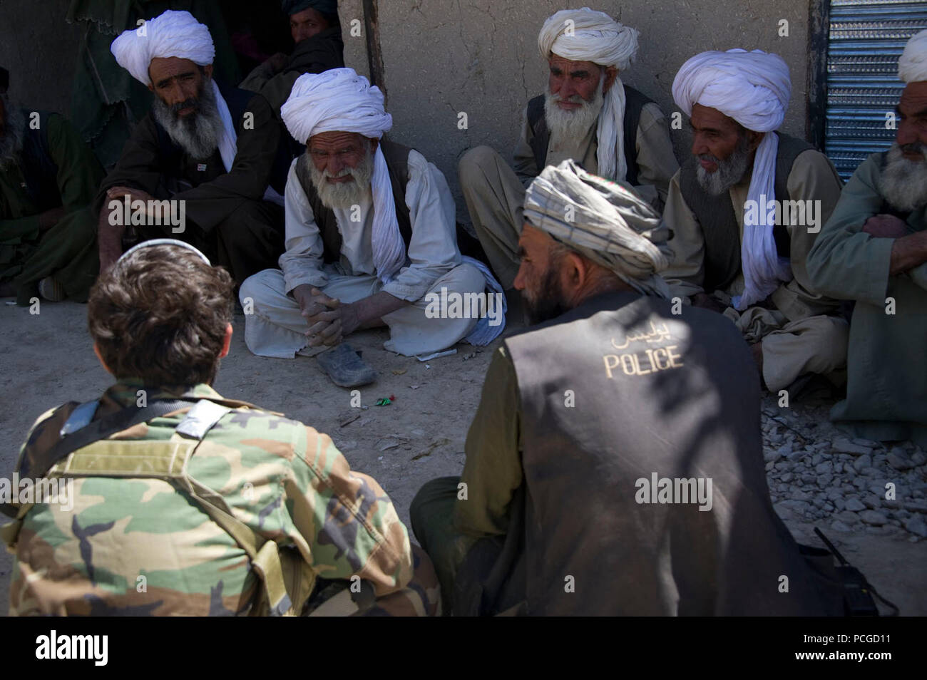 Village elders talk with members of the Afghan National Army special forces and Afghan Local Police about preparations for constructing a water canal for Tagaw district, Uruzgan province, Afghanistan, April 13. The canal will ensure that water collected during the summer will last longer and provide more irrigation water as summer drives on. Stock Photo