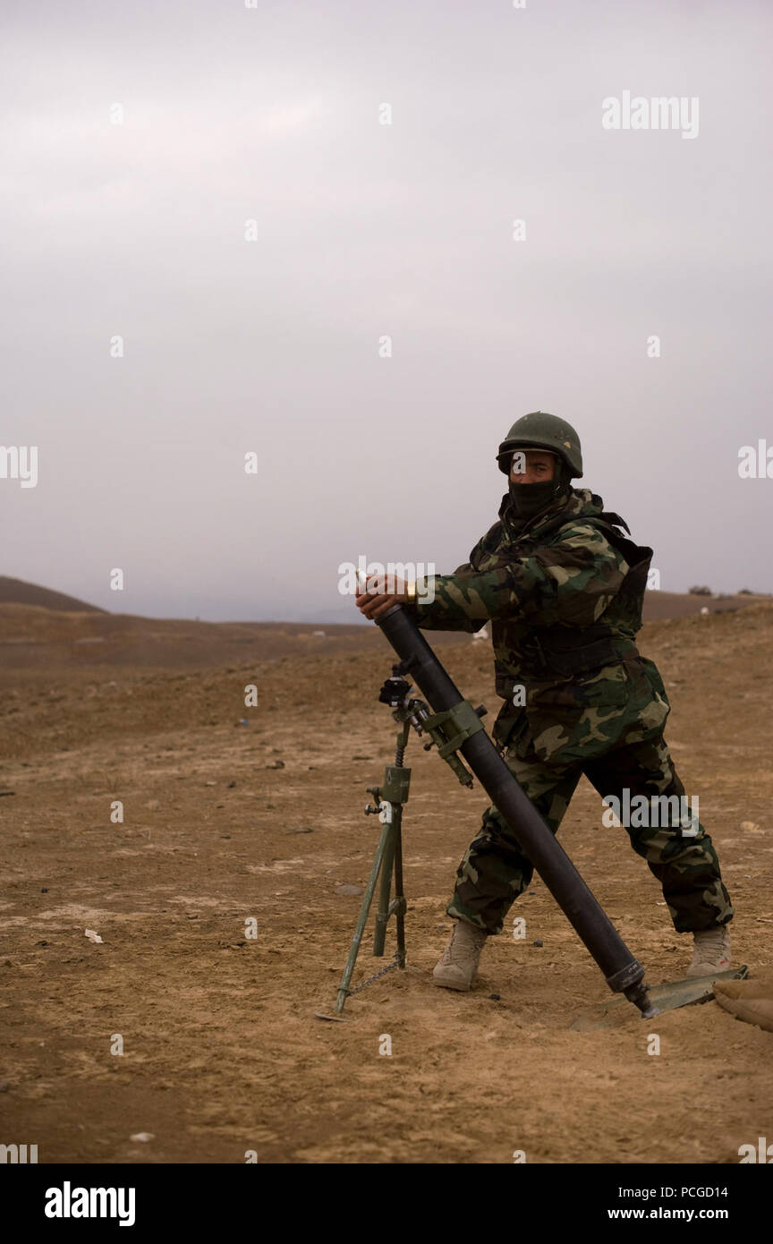 An Afghan National Army soldier prepares to launch an 82 mm mortar at