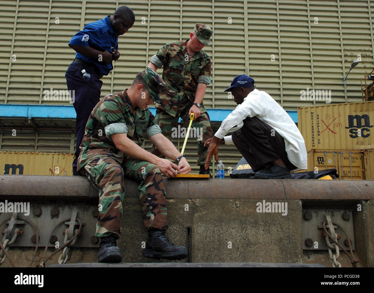 U.S. Navy Lt. Travis Clem, foreground, and Lt. David Trampp, center, both with the Fleet Survey Team, work with Nigerian sailors to construct a tide gauge as part of a cooperative hydrographic survey March 19, 2009, in Lagos, Nigeria, during Africa Partnership Station (APS) 2009. APS is an international security cooperation initiative facilitated by Commander, U.S. Naval Forces Europe-Africa aimed at strengthening global maritime partnerships through training and collaborative activities in order to improve maritime safety and security in Africa. Stock Photo