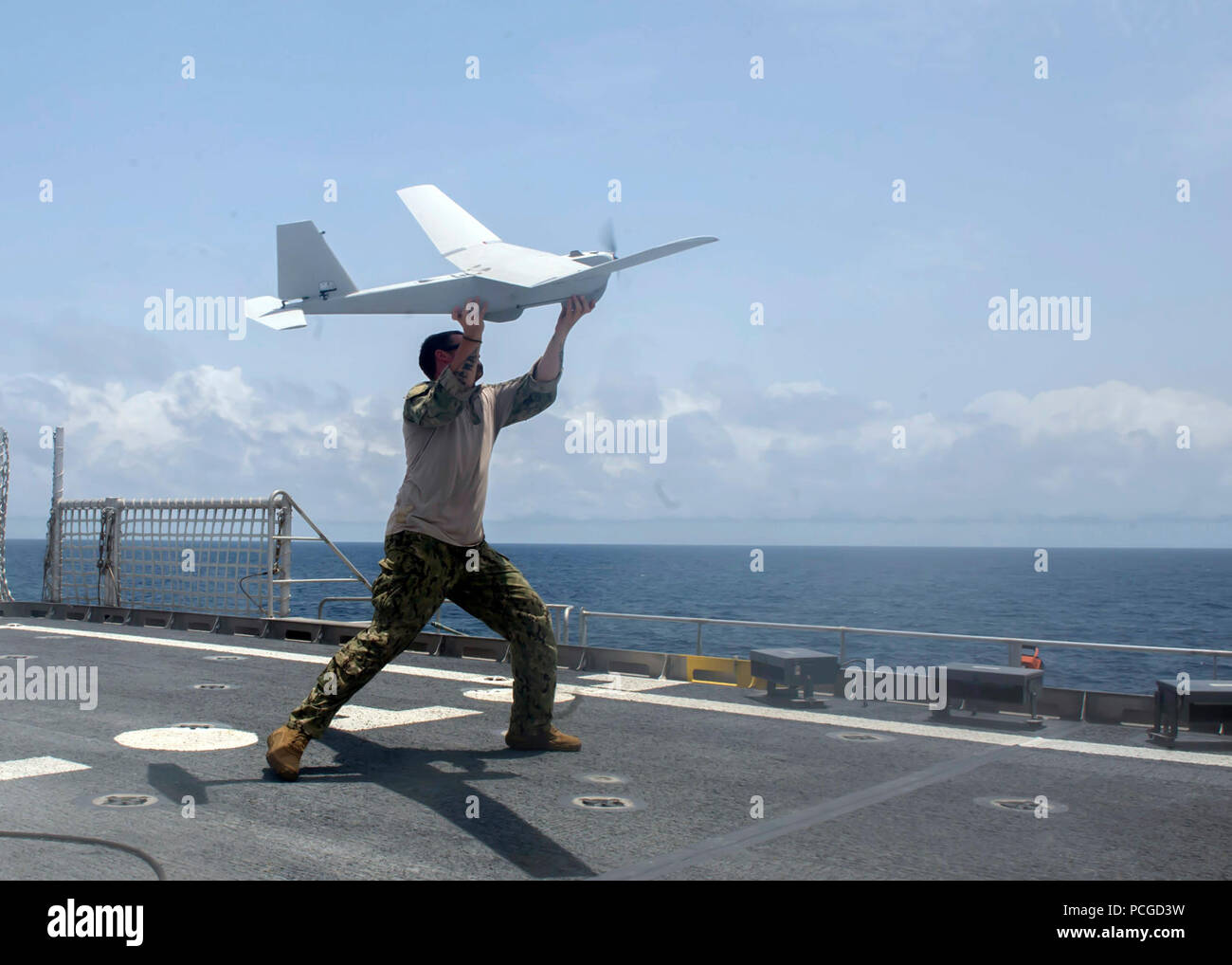 OF GUINEA (March 27, 2014) Fire Controlman 2nd Class Dustin Gower, assigned to the PUMA unmanned aerial vehicle (UAV) detachment aboard the Military Sealift Command joint high-speed vessel USNS Spearhead (JHSV 1), throws a UAV during flight operations as part of a U.S. and Ghana navy combined maritime law enforcement operation under the African Maritime Law Enforcement Partnership program. Stock Photo