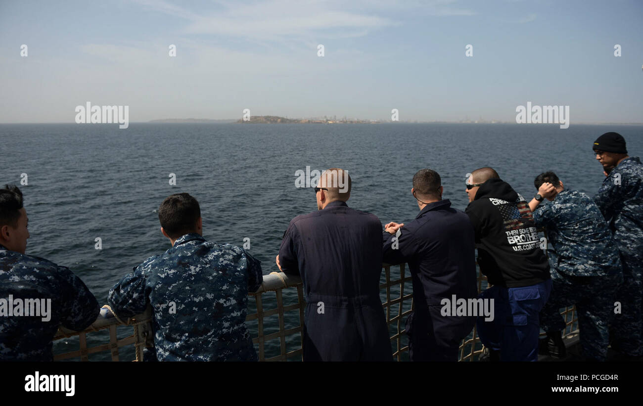 Sailors aboard the Military Sealift Command’s joint high-speed vessel USNS Spearhead (JHSV 1) look out onto the water as the ship pulls in to Dakar, Senegal, Jan. 21, 2015. Spearhead is on a scheduled deployment to the U.S. 6th Fleet area of operations in support of the international collaborative capacity-building program Africa Partnership Station. Stock Photo