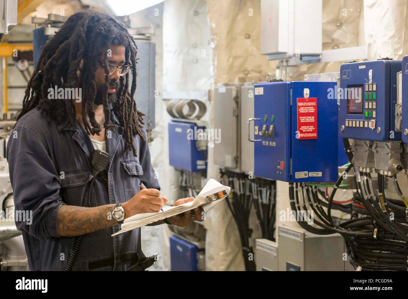 ATLANTIC OCEAN (April 22, 2015) Engine Utilityman Fred Walker, a civil service mariner, updates engineering logs aboard the Military Sealift Command’s joint high-speed vessel USNS Spearhead (JHSV 1) April 22, 2015. Spearhead is on a scheduled deployment to the U.S. 6th Fleet area of operations in support of the international collaborative capacity-building program Africa Partnership Station. Stock Photo