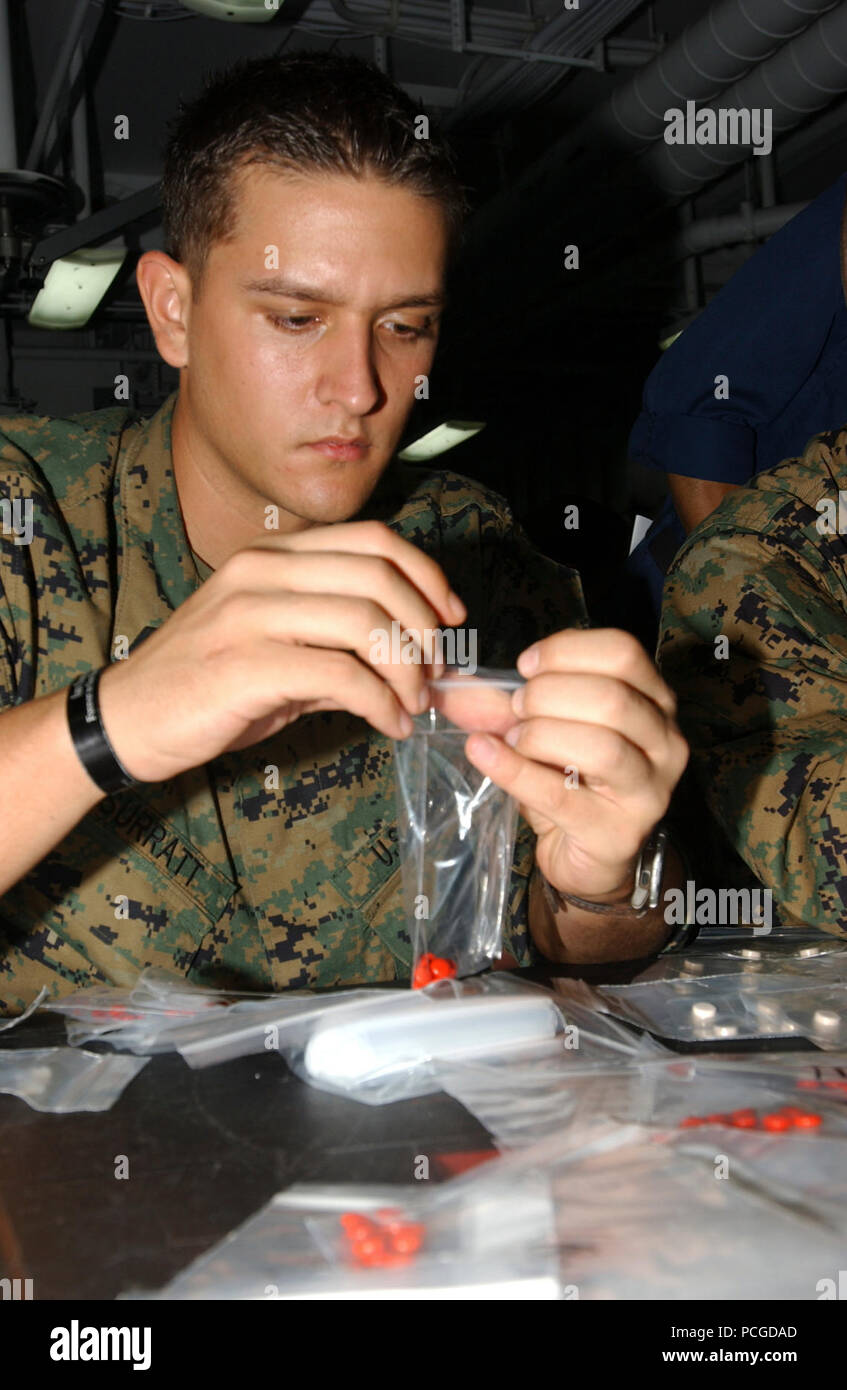 Aboard USS Tarawa (LHA 1), hospital corpsman Beau Surratt, attached to Battalion Landing Team, 1st Battalion, 5th Marines, 11th Marine Expeditionary Unit, fills plastic packets with iron tablets for the people of Bangladesh. (Iron is taken to prevent anemia, the inability of blood to properly clot, caused by malnutrition). Amphibious assault ship Tarawa and embarked 11th Marine Expeditionary Unit are conducting humanitarian assistance/disaster relief efforts in response to the government of Bangladesh's request for assistance after Tropical Cyclone Sidr struck their southern coast Nov. 15. The Stock Photo