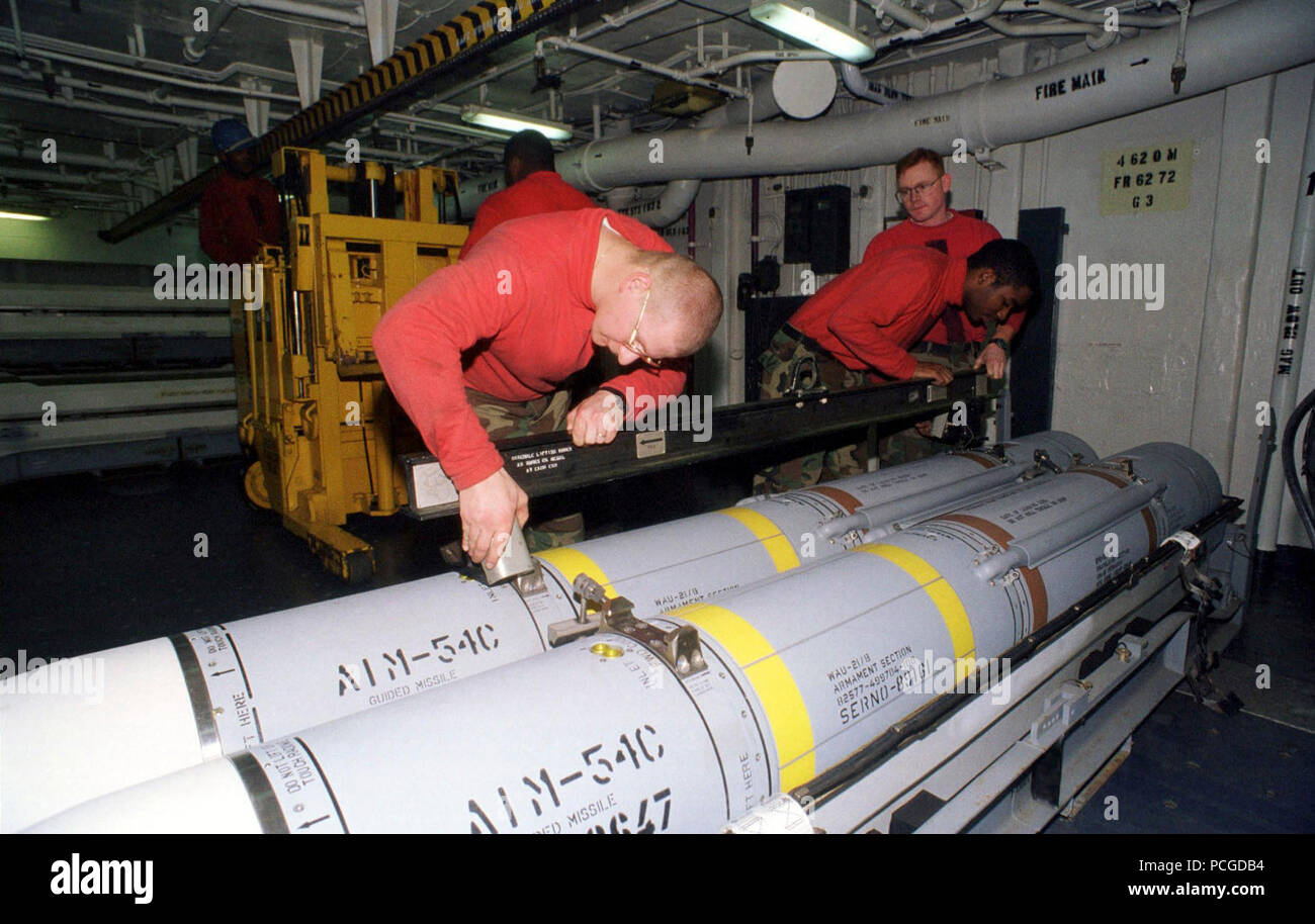 Below decks on the USS ENTERPRISE (CVN 65) members of the Weapons Department build and transport AIM-54 Phoenix, long-range, air-to-air missiles. Stock Photo