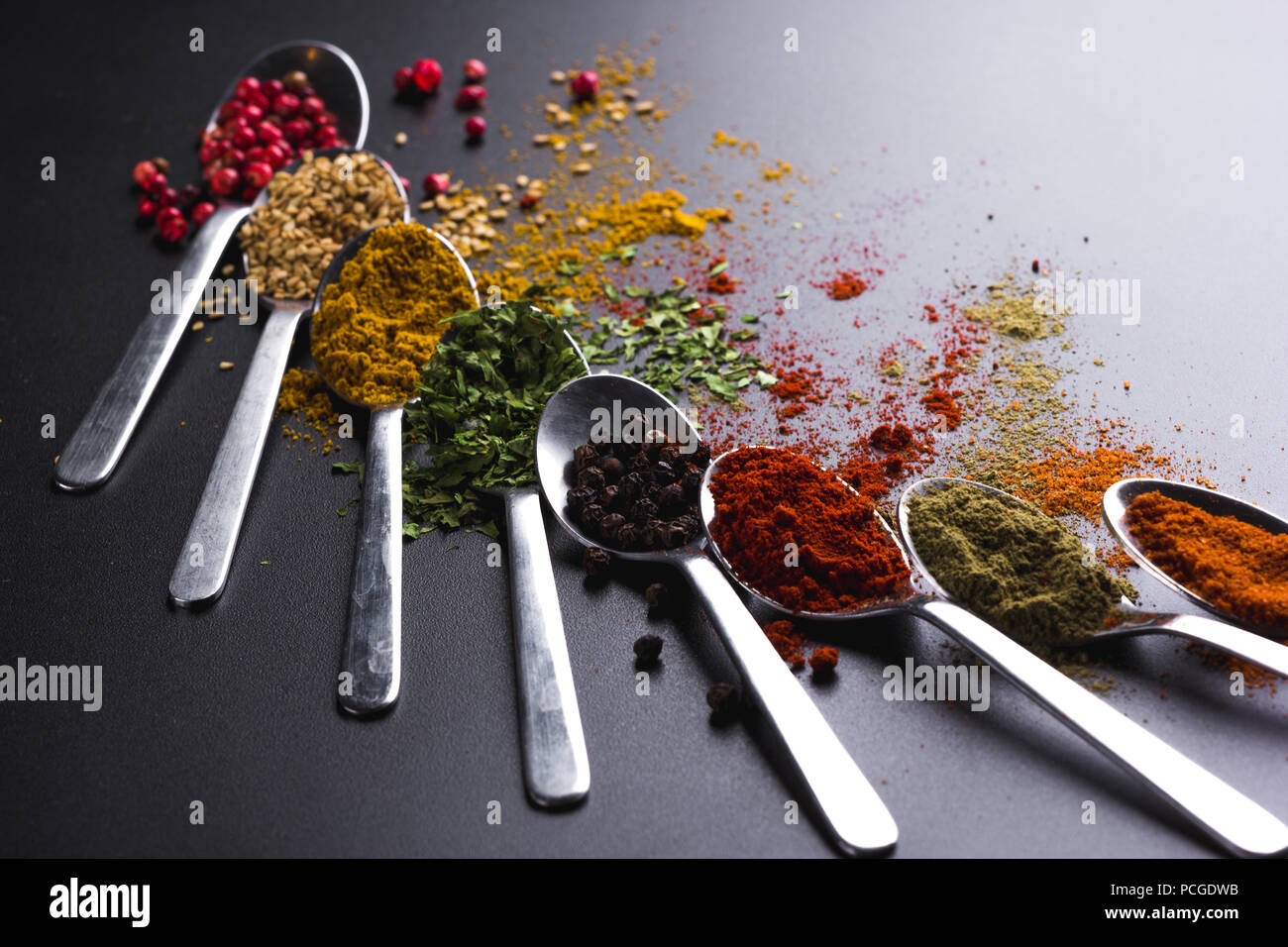 https://c8.alamy.com/comp/PCGDWB/composition-of-small-spoons-full-of-spices-and-condiments-for-cooking-on-a-black-background-PCGDWB.jpg