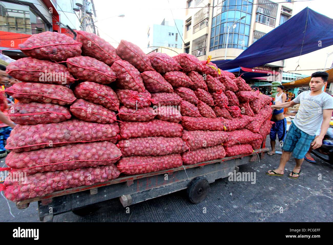 Philippines. 18th May, 2018. Load of onions transported using old wooden push cart along the