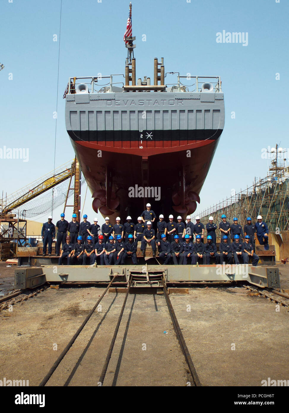 MANAMA, Bahrain (June 17, 2017) The crew of the mine countermeasure ship USS Devastator (MCM 6) stands underneath the ship’s hull before it leaves dry dock. Devastator upgraded in several warfare areas including mine warfare, cyber readiness and engineering as well as improvements to the engineering plant, underwater hull, crew living spaces and the installation of the AN/SLQ-60 SeaFox mine neutralization system. Stock Photo