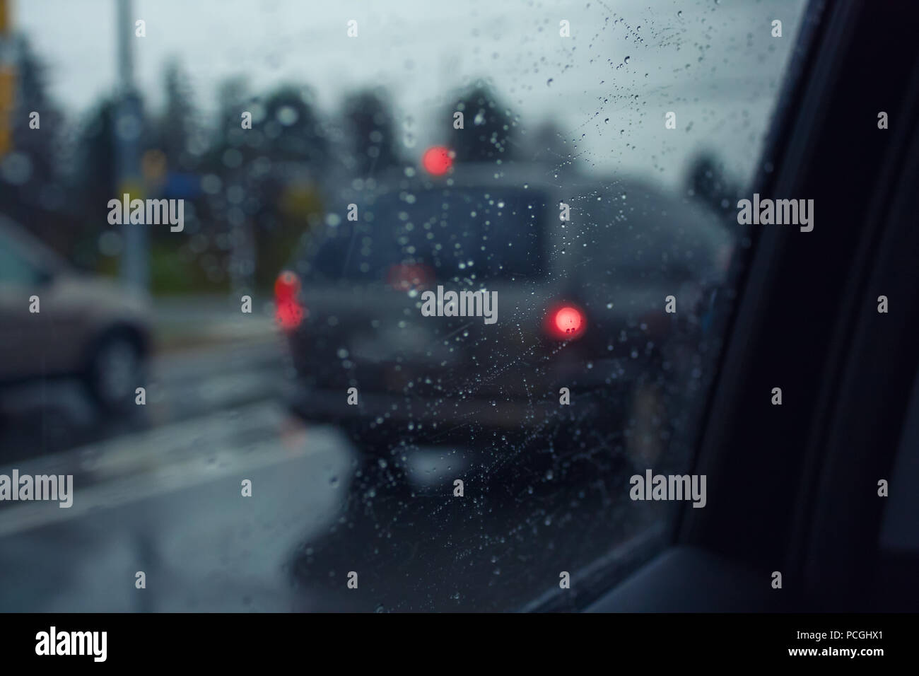 Blurry background with rain drops on car window on a rainy weather on