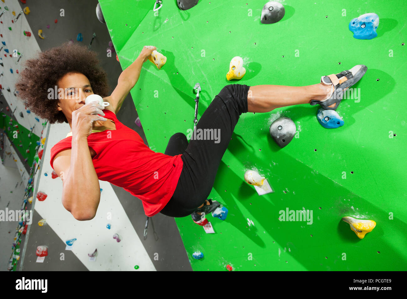 Courageous woman climbing artificial wall hi-res stock photography and ...