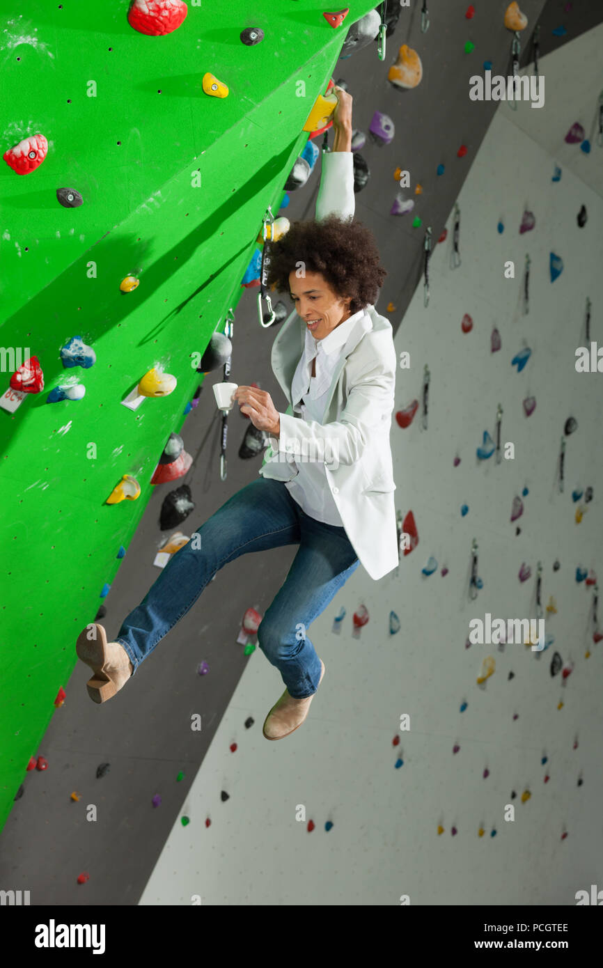 Courageous woman climbing artificial wall hi-res stock photography and ...