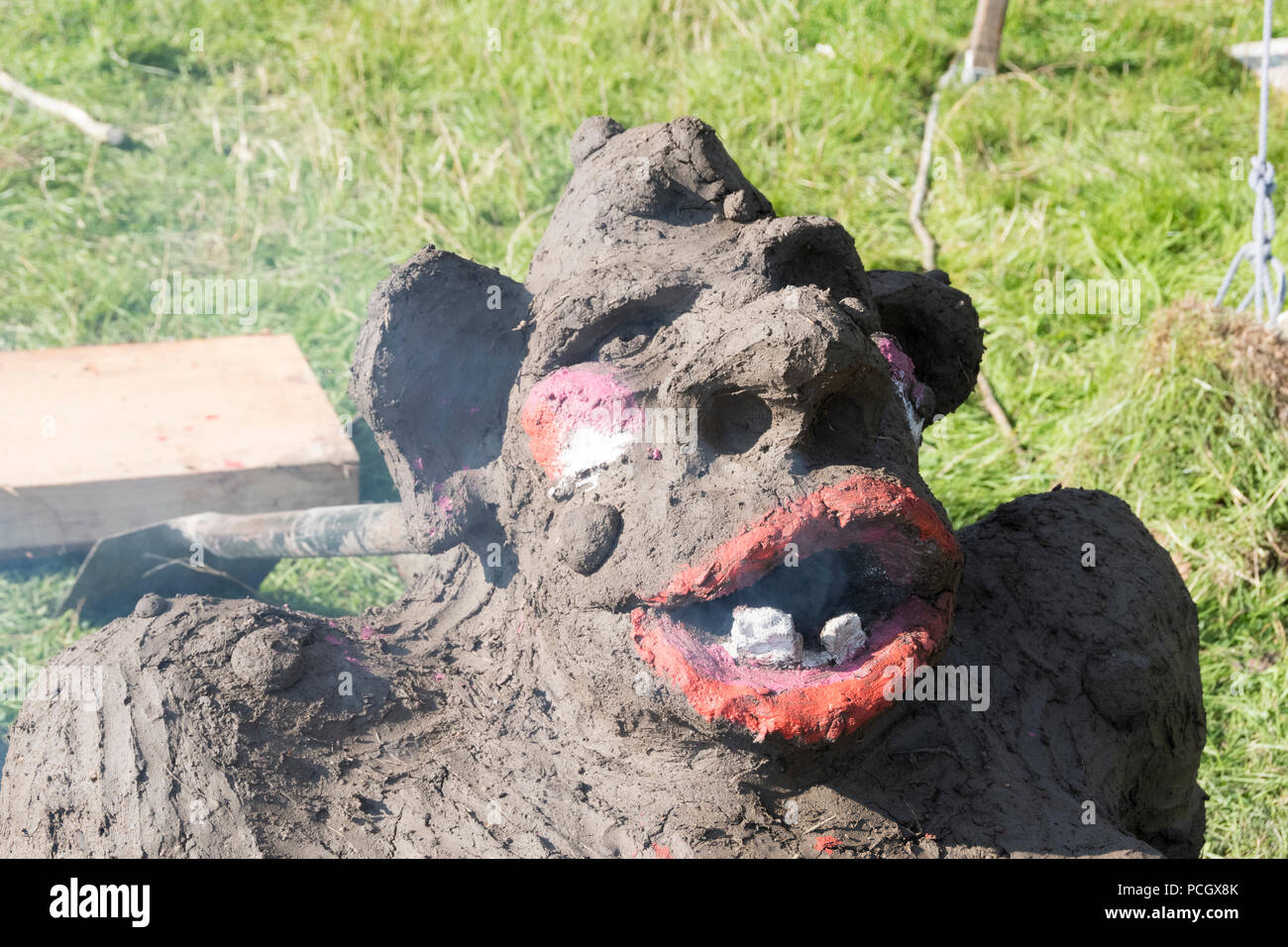 Chepstow, Wales – Aug 14: smoke comes from the mouth of a troll earth oven drying through first bake on 14 Aug 2015 at The Green Gathering Festival Stock Photo