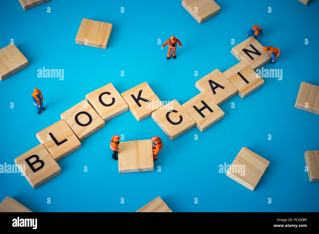 Workers arranging wood with text Blockchain. Stock Photo