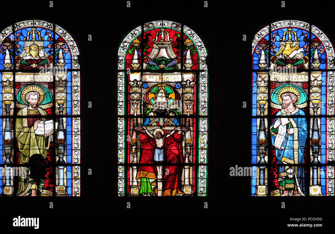 Holy Trinity between Saints Mark and Luke, stained glass window in Saint-Eustache church in Paris, France Stock Photo