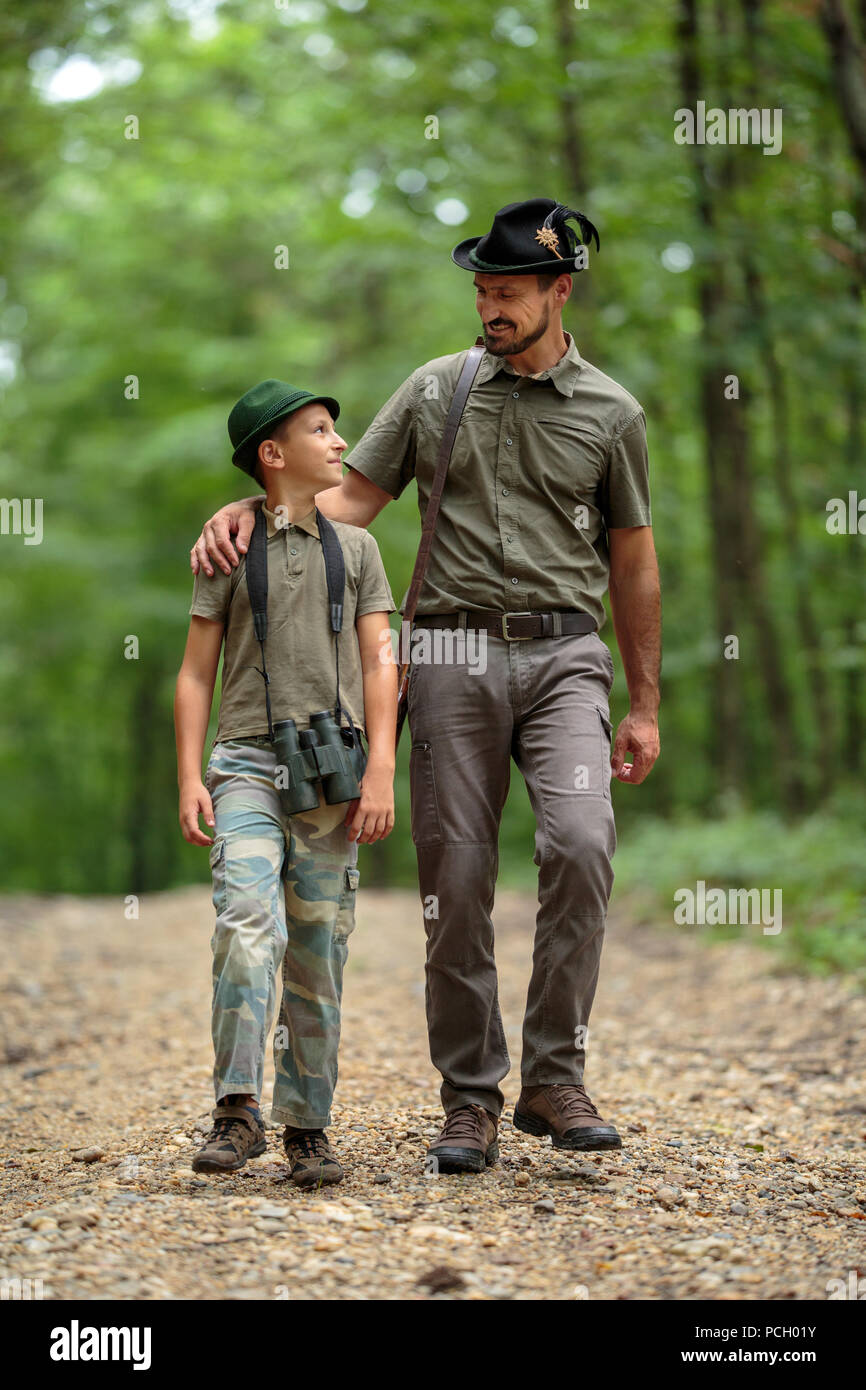 A ranger teaching his son about spotting the game in the wilderness ...