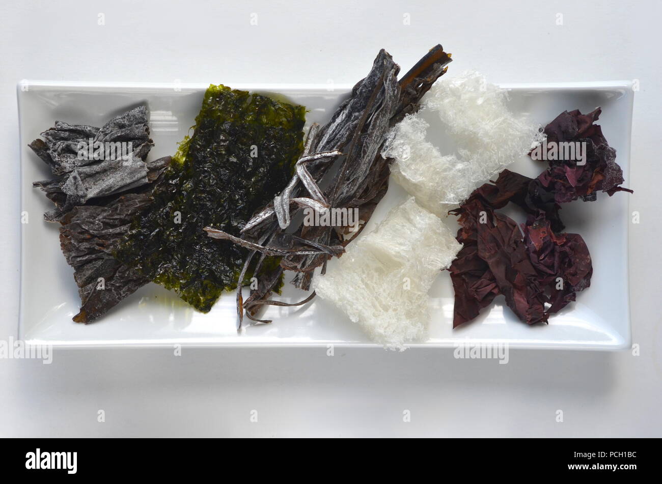 Detail top view of dried seaweed: nori, dulse, kelp, wakame, agar agar, alaria. Isolated on white.Nutrient rich vegan, raw and healthy sea vegetables. Stock Photo