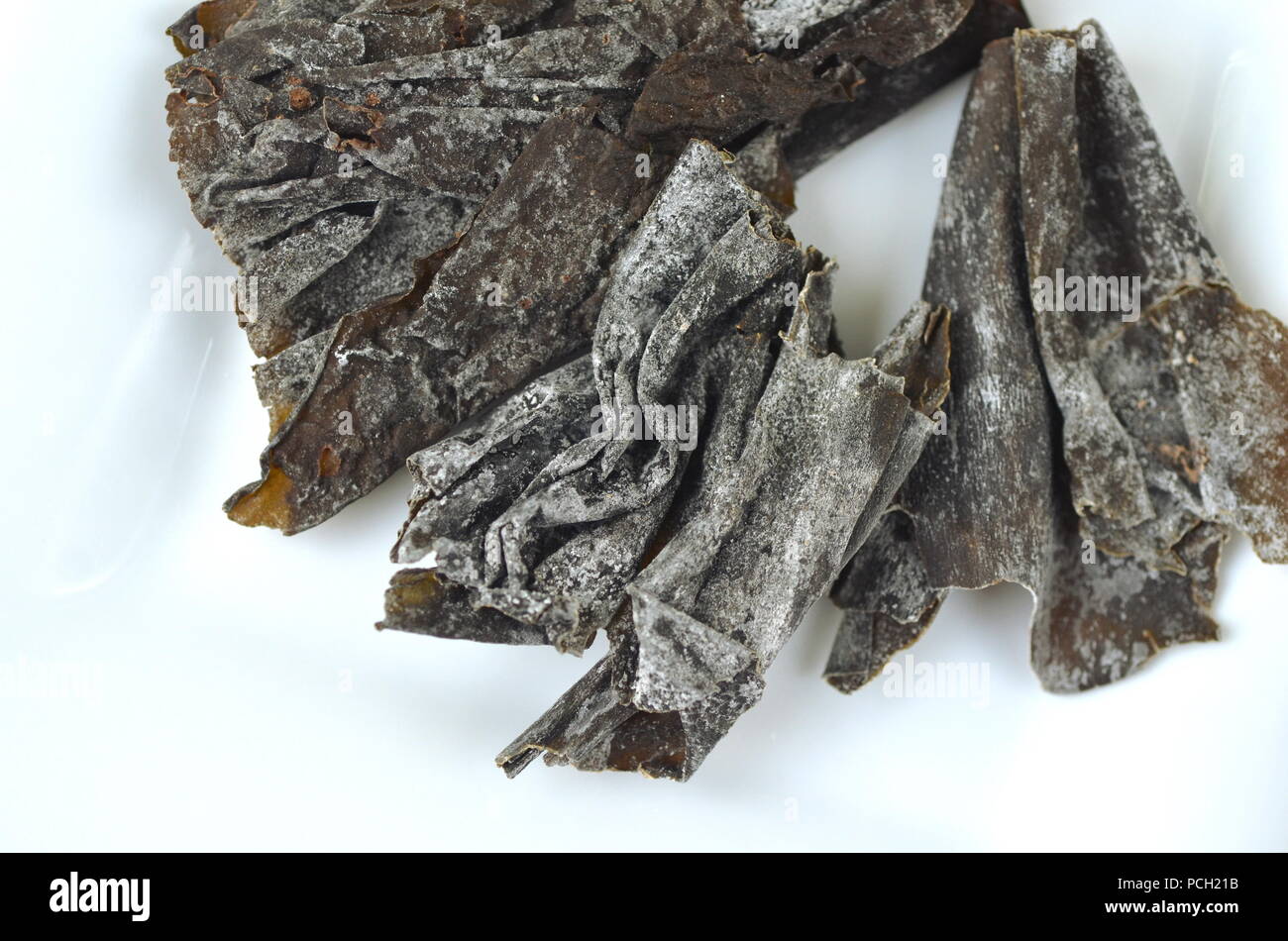 Detail top view of dried seaweed: kelp. Isolated on white.Nutrient rich vegan, raw and healthy sea vegetables. Stock Photo