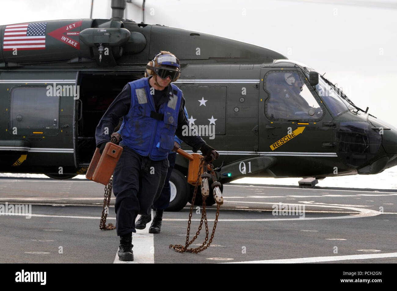 SEA (March 14, 2013) Boatswain's Mate 3rd Class Michael Caruso leaves the launchpad after removing chock and chains from an SH-60F Sea Hawk helicopter aboard the U.S. 7th Fleet flagship USS Blue Ridge (LCC 19). Stock Photo