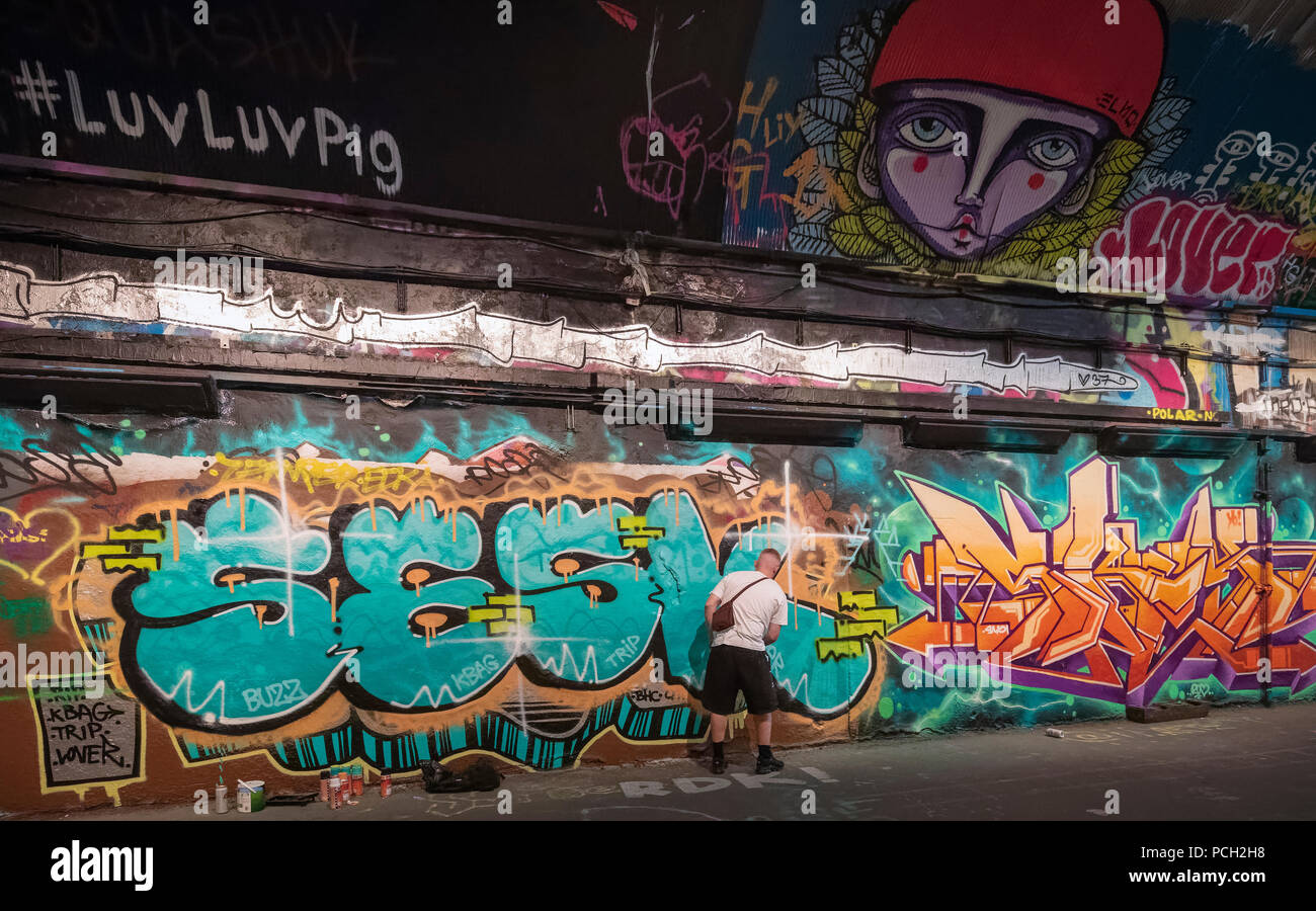 graffiti artist spraying graffiti on wall in London Stock Photo - Alamy