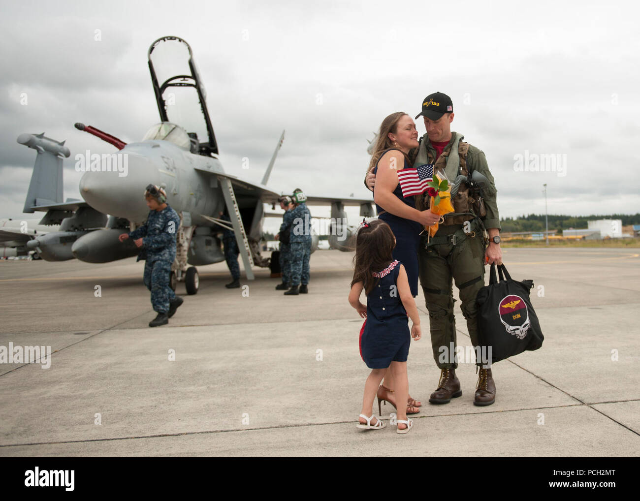 OAK HARBOR, Wash. (Aug. 9, 2016) Lt. Erik Dippold, a Navy pilot assigned to EA-18G Growler Airborne Electronic Attack Aircraft with Electronic Attack Squadron (VAQ) 133 is welcomed home by his wife and daughter at Naval Air Station Whidbey Island. VAQ-133 conducted an eight-month, regularly scheduled, 7th Fleet deployment aboard the USS John C. Stennis (CVN 74) supporting stability in the Indo-Asia-Pacific. Stock Photo