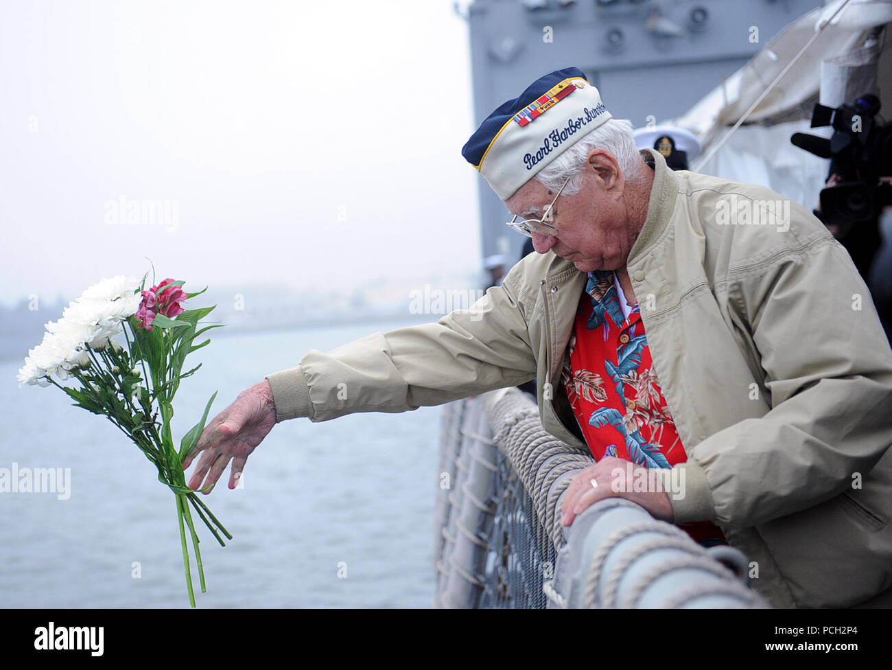 MAYPORT, Fla. (Dec. 7, 2012) Navy Seaman First Class Duane Reyelts, a survivor of the Dec. 7, 1941 Japanese attack on Pearl Harbor, tosses flowers off the side of the guided-missile frigate USS De Wert (FFG 45) during a Pearl Harbor Day ceremony. The ceremony commemorated the anniversary of the Dec. 7, 1941 Japanese attack on Pearl Harbor. Stock Photo