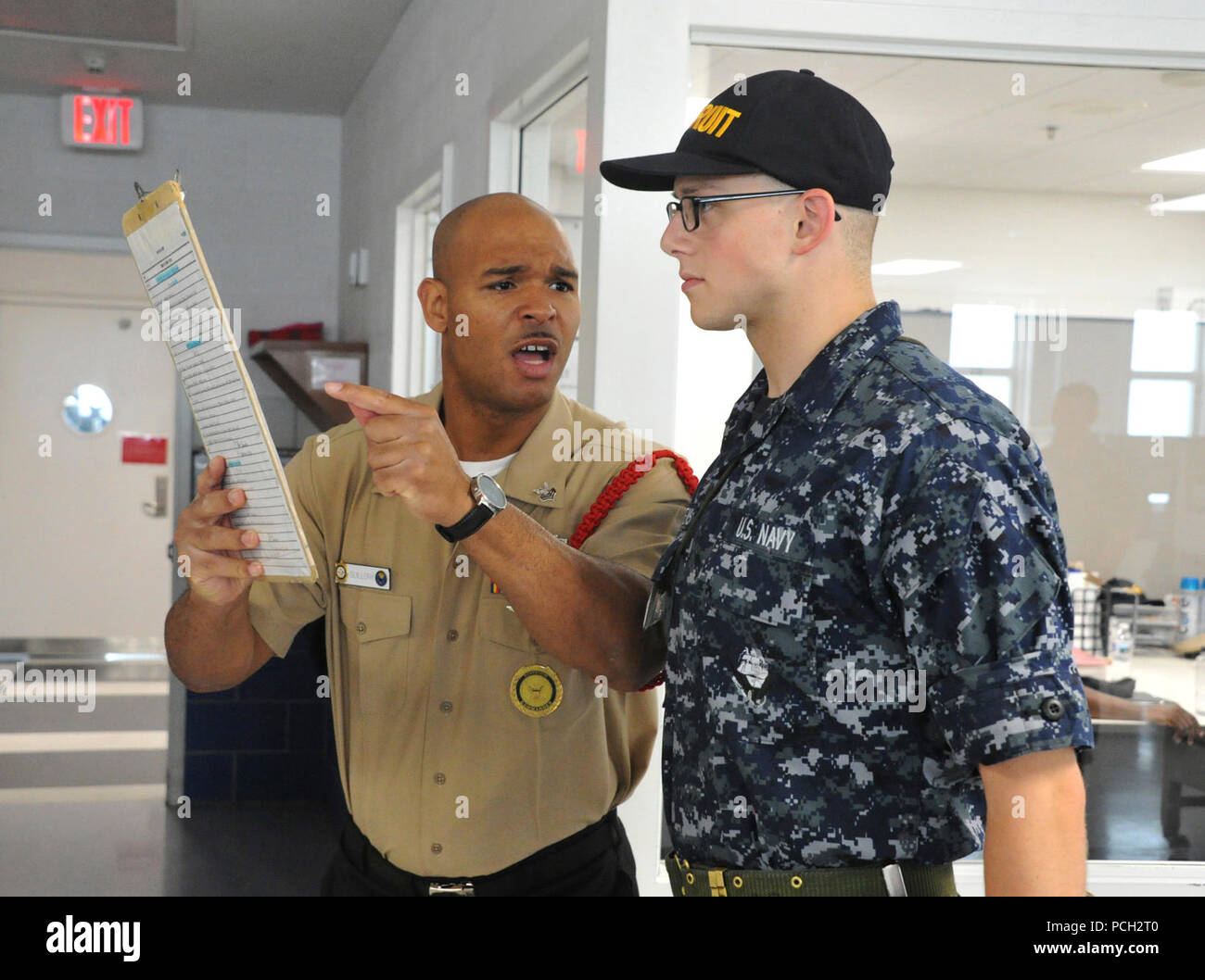 GREAT LAKES, Ill. (June 21, 2017) Logistic Specialist 1st Class Gregory B. Guillory, recruit division commander of Division 817, explains the importance of deck-log accuracy and legibility to a recruit watch-stander on  at Recruit Training Command (RTC). The recruit deck-log is an important training aid that not only records divisional activities, but also teaches recruits attention to detail. Approximately 30,000-40,000 recruits graduate annually from RTC. Stock Photo