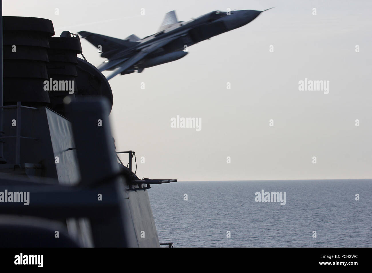 BALTIC SEA - A Russian Sukhoi Su-24 attack aircraft makes a very-low altitude pass by the USS Donald Cook (DDG 75) April 12, 2016. Donald Cook, an Arleigh Burke-class guided-missile destroyer, forward deployed to Rota, Spain is conducting a routine patrol in the U.S. 6th Fleet area of operations in support of U.S. national security interests in Europe. Stock Photo