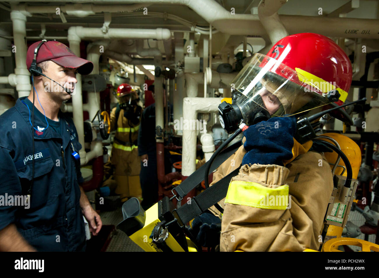 EAST CHINA SEA, Japan (July 21, 2012) Damage Controlman 3rd Class Aret Gross, right, calls in the status of a fire during a simulated engineering casualty aboard the Arleigh Burke-class guided-missile destroyer USS McCampbell (DDG 85). McCampbell is forward deployed to Yokosuka, Japan, and is underway in the U.S. 7th Fleet area of responsibility. Stock Photo