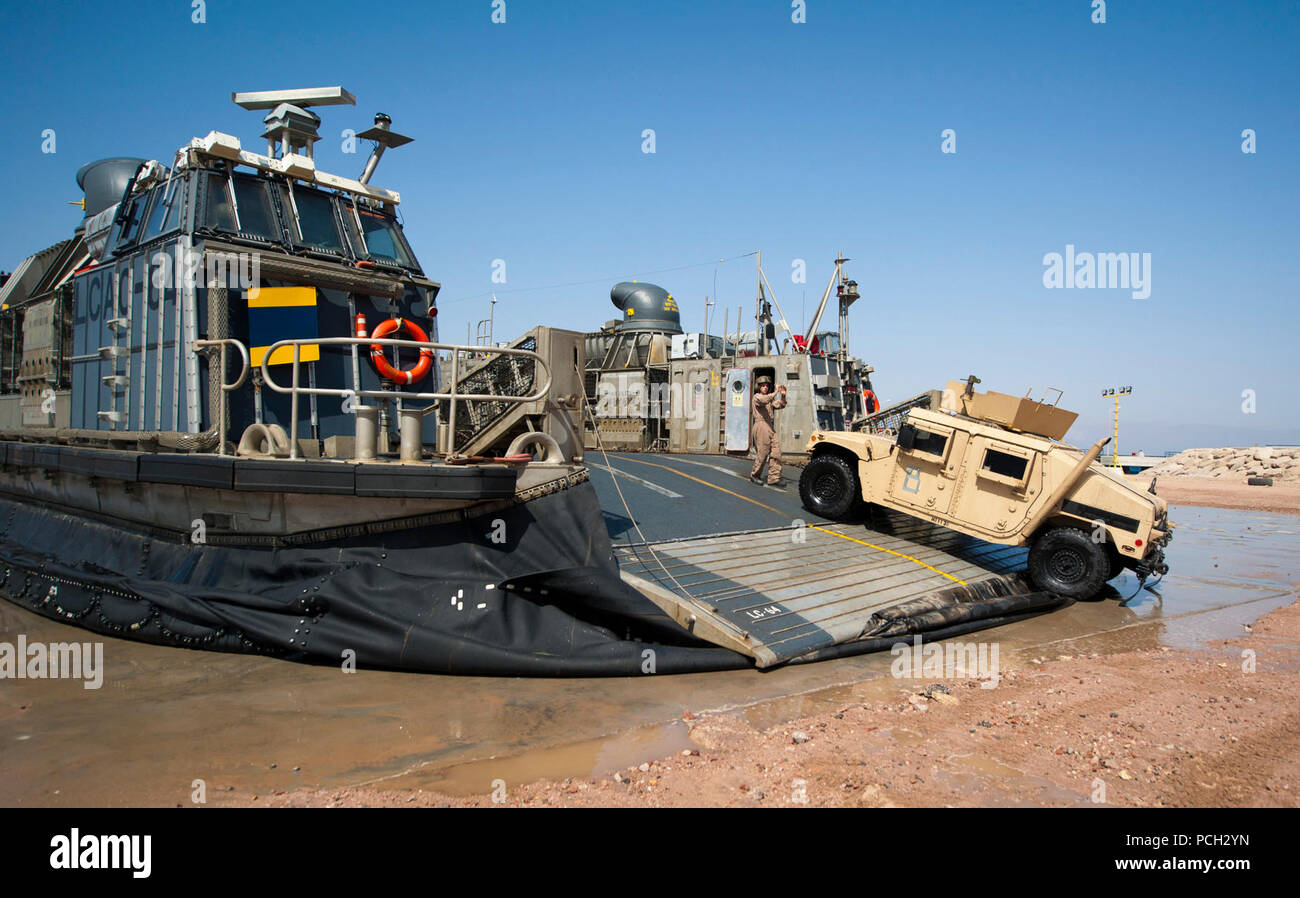 U.S. 5TH FLEET AREA OF RESPONSIBILITY (April 24, 2012) Boatswain’s Mate Seaman Christopher Robo, assigned to Assault Craft Unit (ACU) 5, directs a Humvee as it debarks a landing craft air cushion. ACU-5 is deployed with the amphibious transport dock ship USS New Orleans (LPD 18). New Orleans and embarked 11th Marine Expeditionary Unit (11th MEU) are deployed as part of the Makin Island Amphibious Ready Group, supporting maritime security operations and theater security cooperation efforts in the U.S. 5th Fleet area of responsibility. Stock Photo