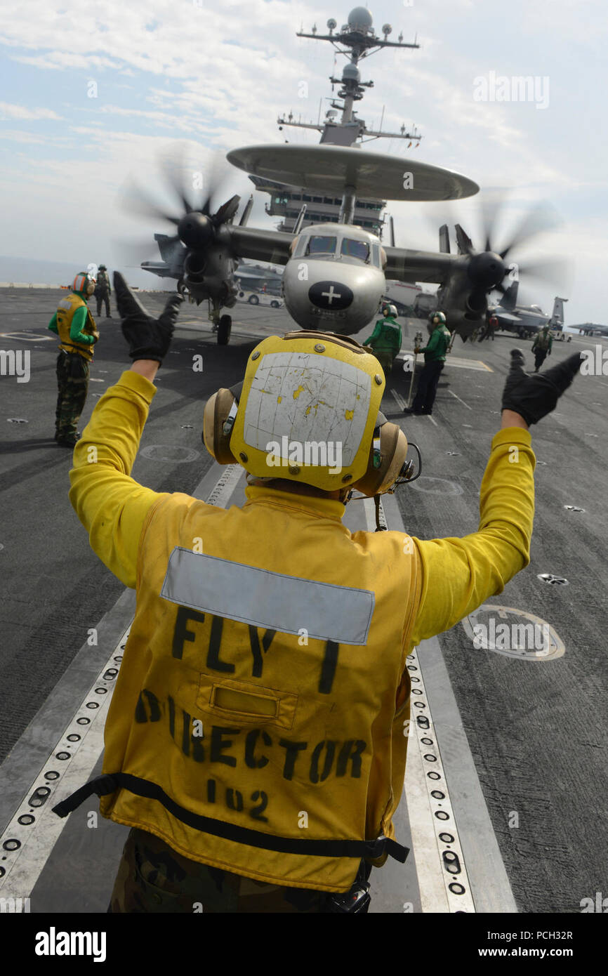 ARABIAN SEA (Dec. 08, 2012) Aviation Boatswain's Mate (Handling) 3rd Class Robert Vitolo, from Tuscon, Ariz., directs an E-2C Hawkeye from the Golden Hawks of Airborne Early Warning Squadron (VAW) 112 aboard the aircraft carrier USS John C. Stennis (CVN 74). John C. Stennis is deployed to the U.S. 5th Fleet area of responsibility conducting maritime security operations, theater security cooperation efforts and support missions for Operation Enduring Freedom. Stock Photo