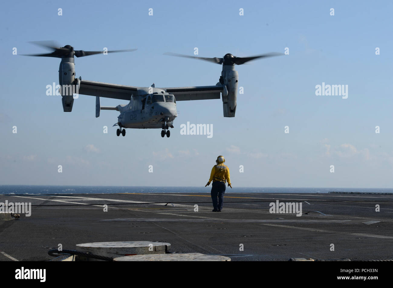 ATLANTIC OCEAN (Jan. 29, 2013) Aviation Boatswain's Mate (Handling) 2nd Class Luiz Diaz signals to an MV-22 Osprey from Marine Tiltrotor Operational Test and Evaluation Squadron (VMX) 22 as it prepares to land on the flight deck of the aircraft carrier USS George H.W. Bush (CVN 77). George H.W. Bush is conducting training and carrier qualifications in the Atlantic Ocean. Stock Photo
