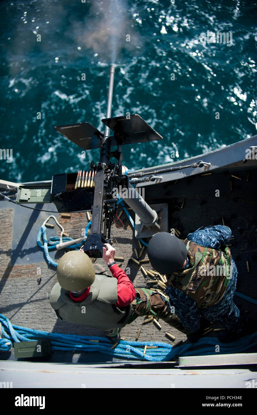 ARABIAN GULF (Feb. 6, 2012) A Sailor fires a .50-caliber machine gun, as Gunner’s Mate 2nd Class Adrian Rodziewicz observes for safety during a live-fire exercise aboard the amphibious transport dock ship USS New Orleans (LPD 18). New Orleans and embarked Marines assigned to the 11th Marine Expeditionary Unit (11th MEU) are deployed as part of the Makin Island Amphibious Ready Group, supporting maritime security operations and theater security cooperation efforts in the U.S. 5th Fleet area of responsibility. Stock Photo