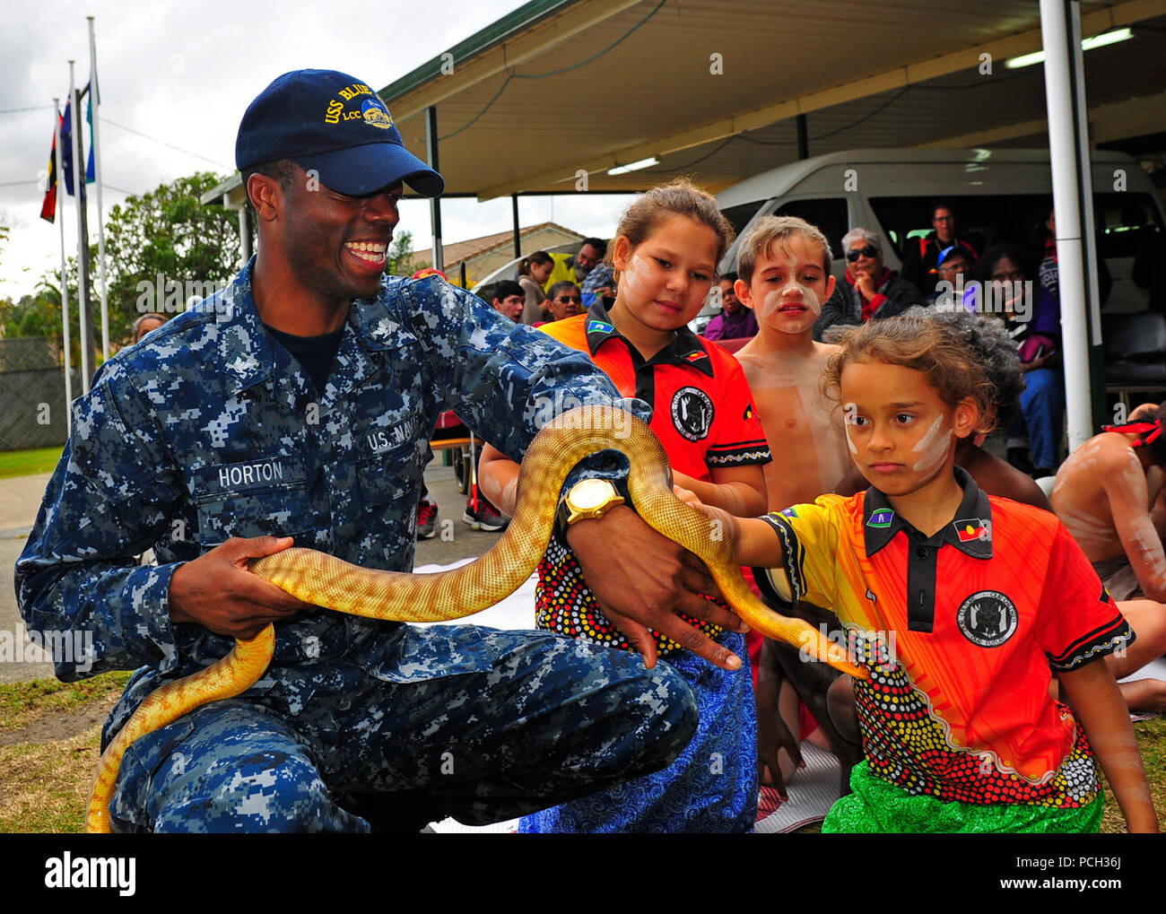 BRISBANE, Australia (July 21, 2015) Culinary Specialist 3rd Class Dearra Horton, assigned to the U.S. 7th Fleet flagship USS Blue Ridge (LCC 19), holds a snake to show students from the Aboriginal and Islander Independent Community School during a community service event at Burringilly Aboriginal Corporation. Blue Ridge is conducting a port visit in Brisbane while patrolling the 7th Fleet area of operations. Stock Photo