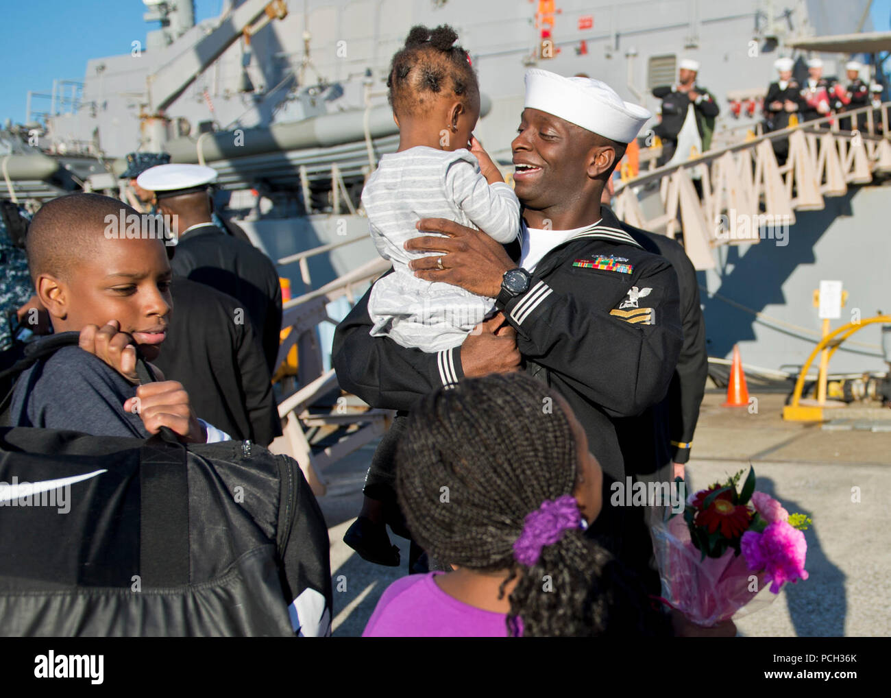 YOKOSUKA, Japan (Nov. 16, 2012) Culinary Specialist 1st Class Tony Alston greets his children during a homecoming event for the Arleigh Burke-class guided-missile destroyer USS Stethem (DDG 63) at Fleet Activities, Yokosuka. Stethem is assigned to Destroyer Squadron (DESRON) 15 and forward deployed to Yokosuka, Japan. The U.S. Navy is constantly deployed to preserve peace, protect commerce, and deter aggression through forward presence. Join the conversation on social media using #warfighting. Stock Photo