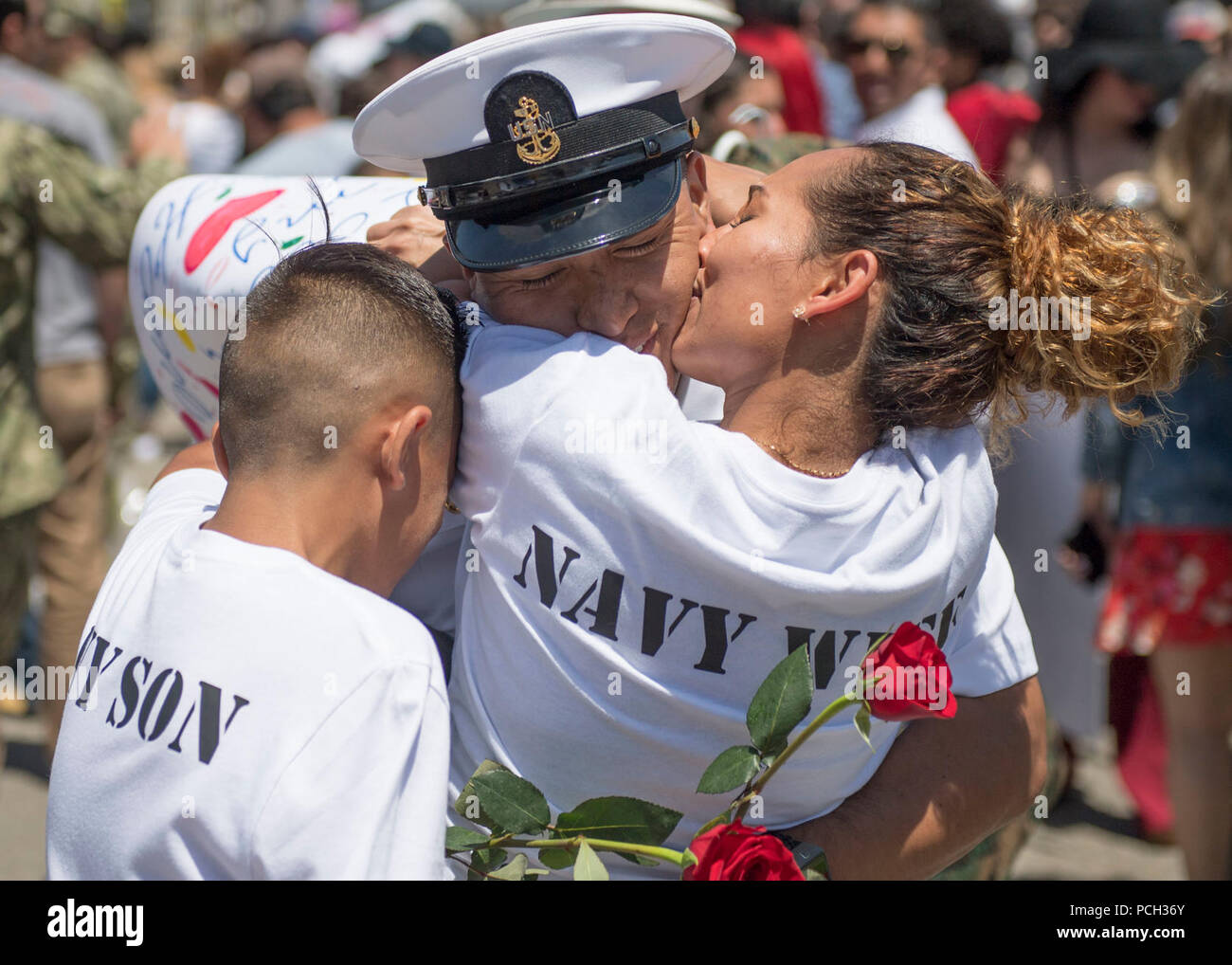 SAN DIEGO (May 7, 2018) Chief Aviation Boatswain’s Mate (Fuel) Miguel Mosquera, assigned to the Nimitz-class aircraft carrier USS Theodore Roosevelt (CVN 71), hugs his family upon the ship's return from a scheduled deployment. Theodore Roosevelt departed San Diego, Oct. 6, 2017 and spent the deployment supporting Operations Inherent Resolve and Freedom’s Sentinel, as well as maritime security cooperation efforts in U.S. 5th and 7th Fleet areas of operation. Stock Photo