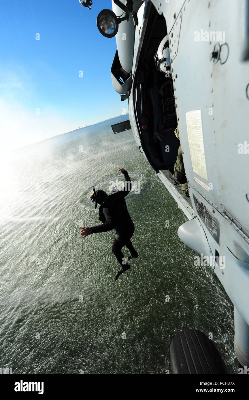 NORFOLK (Oct. 22, 2012) A naval air crewman assigned to Helicopter Sea Combat Squadron (HSC) 9 jumps from an MH-60S Sea Hawk helicopter during simulated search and rescue operations. Stock Photo