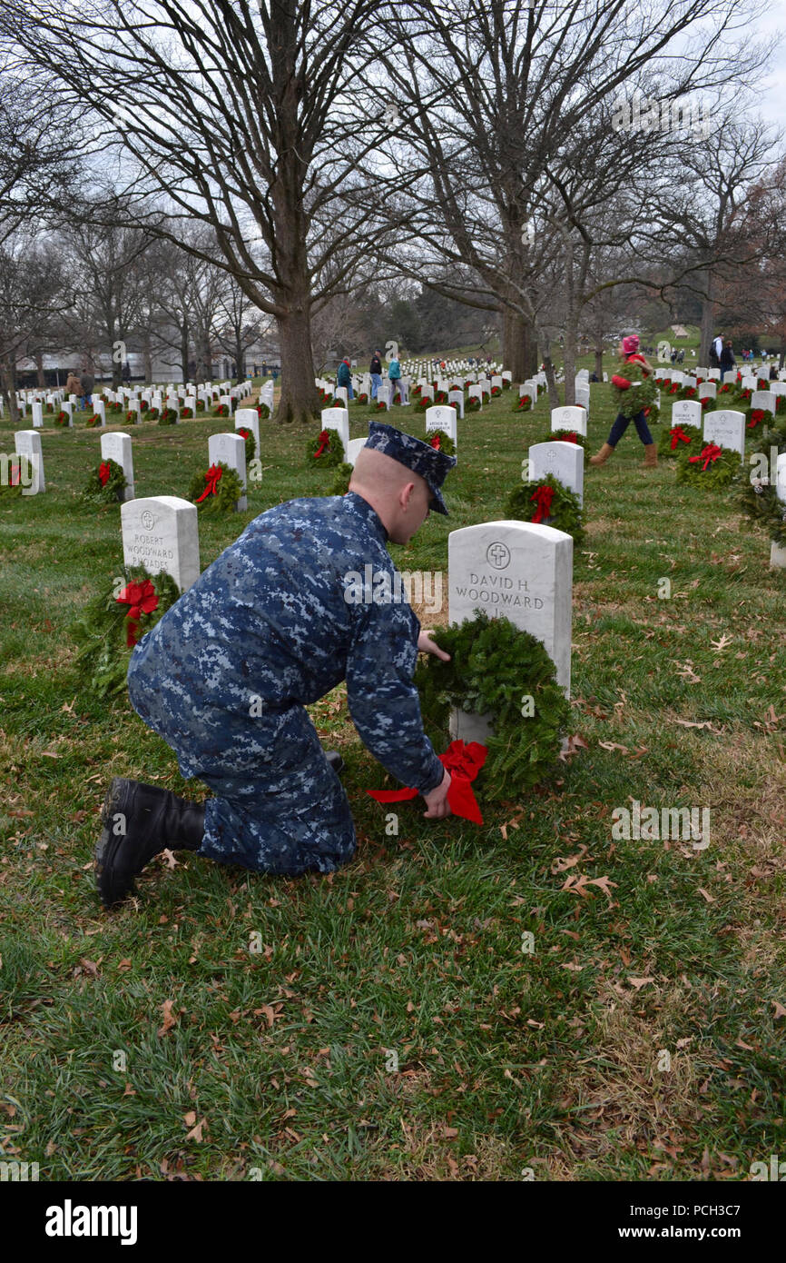 ARLINGTON, Va. (Dec. 15, 2012) Religious Program Specialist 3rd Class Richie Greene places a wreath on a veteran's grave in Arlington National Cemetery. Greene was among 40 Sailors from the Pentagon who volunteered to distribute and lay wreaths at the Wreaths Across America event in Arlington National Cemetery. This event, held annually at national cemeteries across the country, seeks to pay respects to our nation's veterans by laying wreaths on their grave. Stock Photo