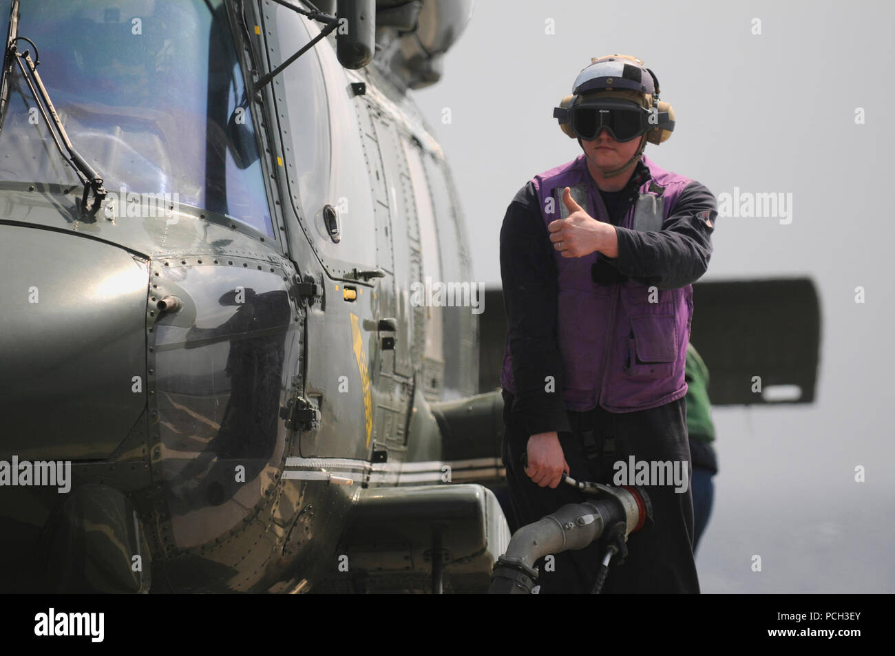 SEA (March 14, 2013) Engineman 2nd Class David Kirchens signals in preparation to refuel an SH-60F Sea Hawk helicopter aboard the U.S. 7th Fleet flagship USS Blue Ridge (LCC 19). Stock Photo