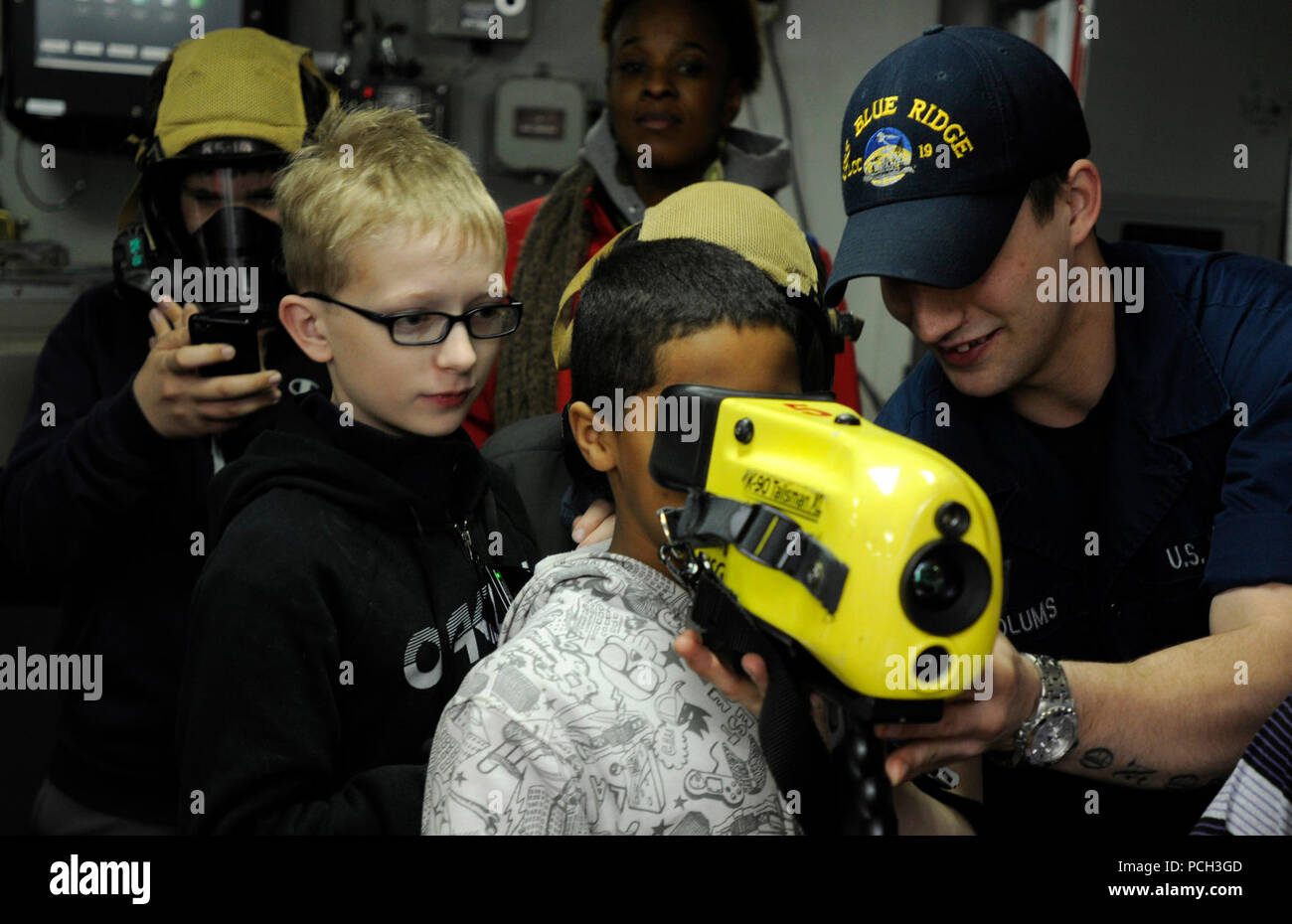 YOKOSUKA, Japan (Feb. 15, 2013) Damage Controlman Fireman Steven Woolums shows students from Yokosuka Middle School a Navy Firefighters Thermal Imager in damage control central during a ship tour aboard U.S. 7th Fleet flagship the amphibious command ship USS Blue Ridge (LCC 19). Stock Photo