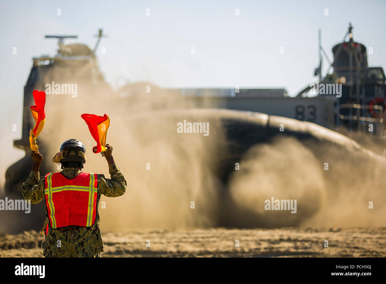 CAMP LEJEUNE, N.C. (Nov. 5, 2017) A U.S. Navy Sailor signals Landing Craft, Air Cushion 83, to embark on the amphibious assault ship USS Iwo Jima (LHD-7) as part of a Composite Training Unit Exercise (COMPTUEX) at Onslow Beach. The 26th Marine Expeditionary Unit (MEU) is conducting a COMPTUEX in preparation for an upcoming deployment at sea. Stock Photo