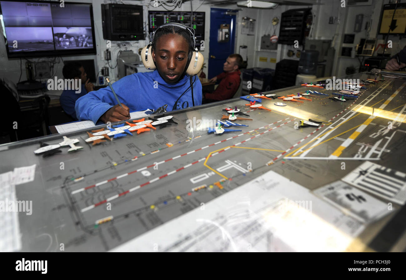 GULF OF OMAN (June 18, 2013) Aviation Boatswain’s Mate (Handling) Airman Janine Hunt, from Stockton, Calif., makes adjustments to the flight deck control Ouija board in the flight control office aboard the aircraft carrier USS Nimitz (CVN 68).  The Nimitz Carrier Strike Group is deployed to the U.S. 5th Fleet area of responsibility conducting maritime security operations, theater security cooperation efforts and support missions for Operation Enduring Freedom. Stock Photo