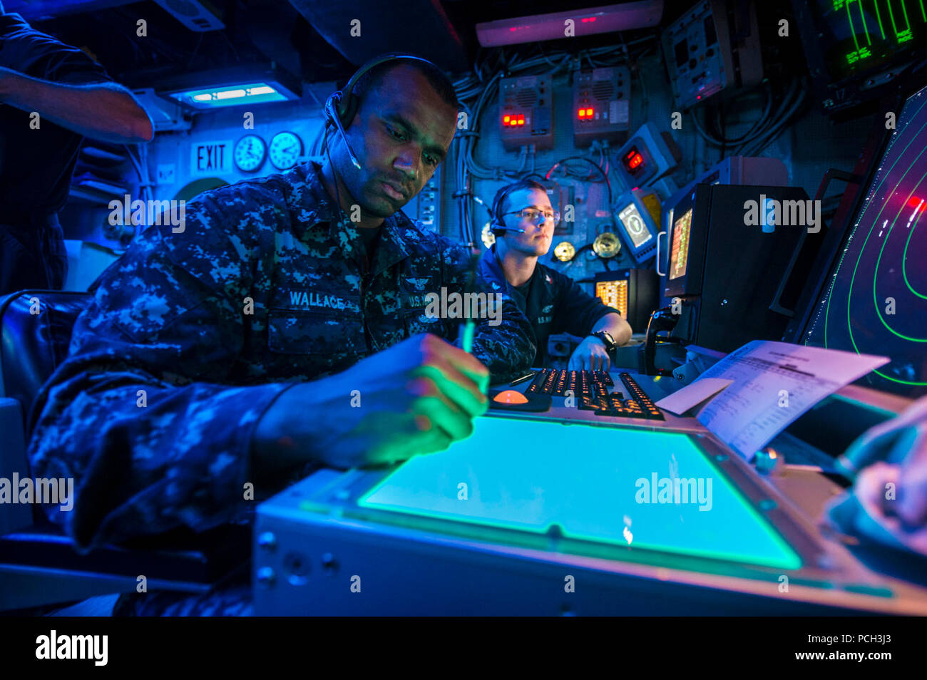 CORAL SEA (July 6, 2013) Air Traffic Controlman 2nd Class Timothy Wallace, left, and Air Traffic Controlman 2nd Class Clayton Alexander, assigned to the amphibious assault ship USS Bonhomme Richard (LHD 6), observe radar signatures in the ship's air traffic control room. Bonhomme Richard is the flagship of the Bonhomme Richard Amphibious Ready Group and, with the embarked 31st Marine Expeditionary Unit (31st MEU) is conducting routing joint-force operations in the U.S. 7th Fleet Area of Responsibility. Stock Photo